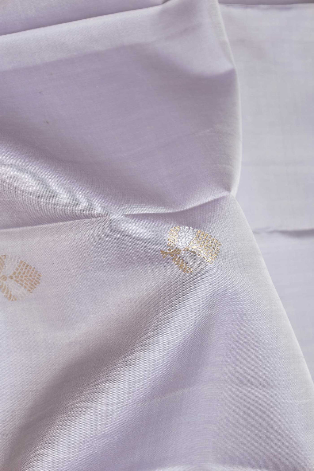 Close up of Pure Silk Pure Zari Grey Dual Tone Kanchipuram Saree with Zari Butta on the body and Zari Border displaying folds