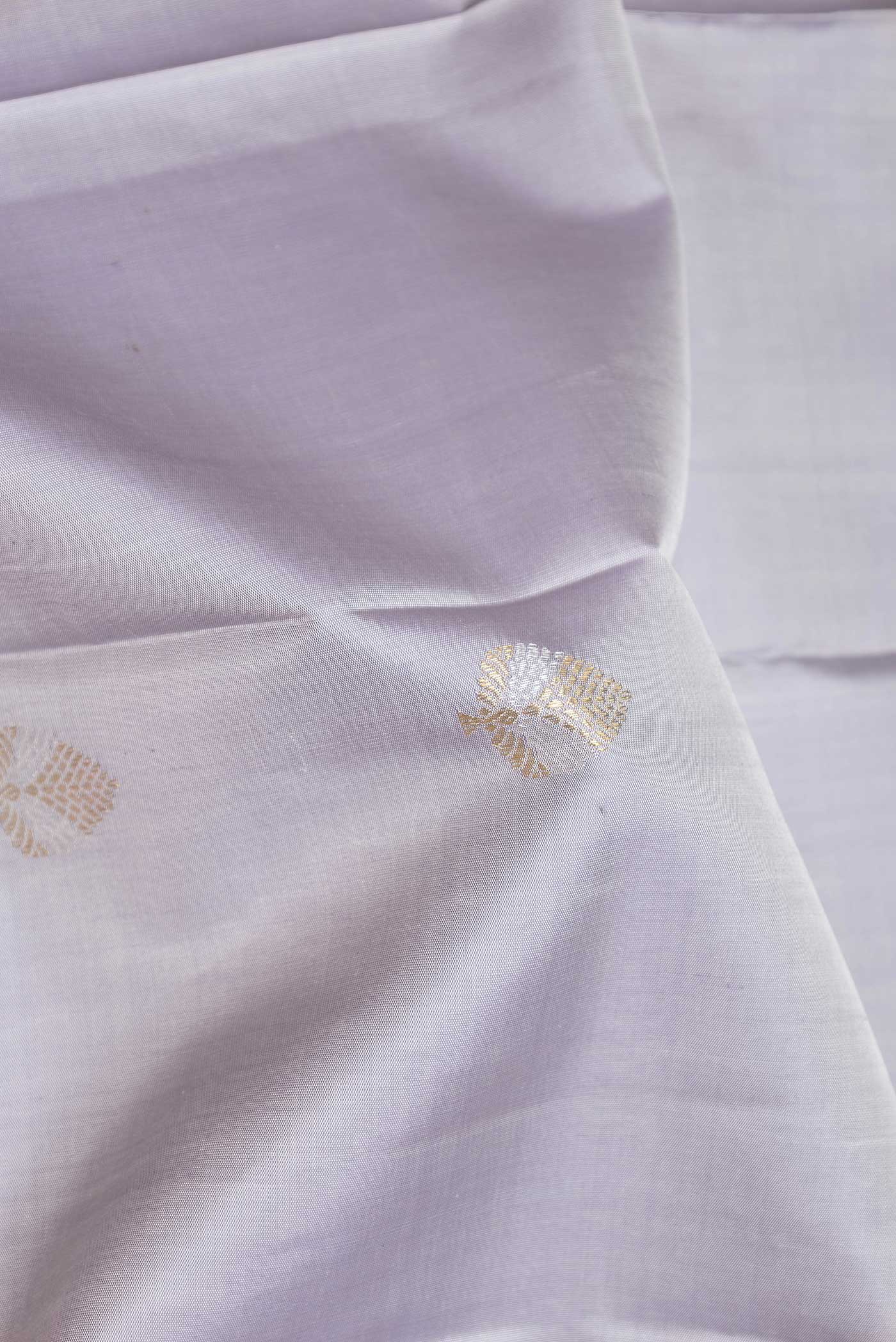 Close up of Pure Silk Pure Zari Grey Dual Tone Kanchipuram Saree with Zari Butta on the body and Zari Border displaying folds