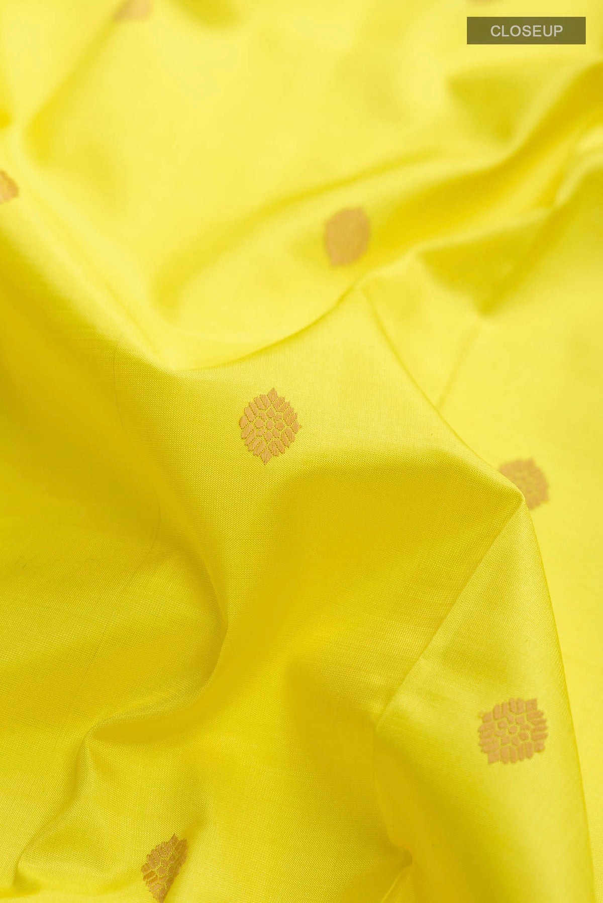 Close up of Yellow Kanchipuram Silk Saree with Thread Butta on the body and Thread Border displaying folds