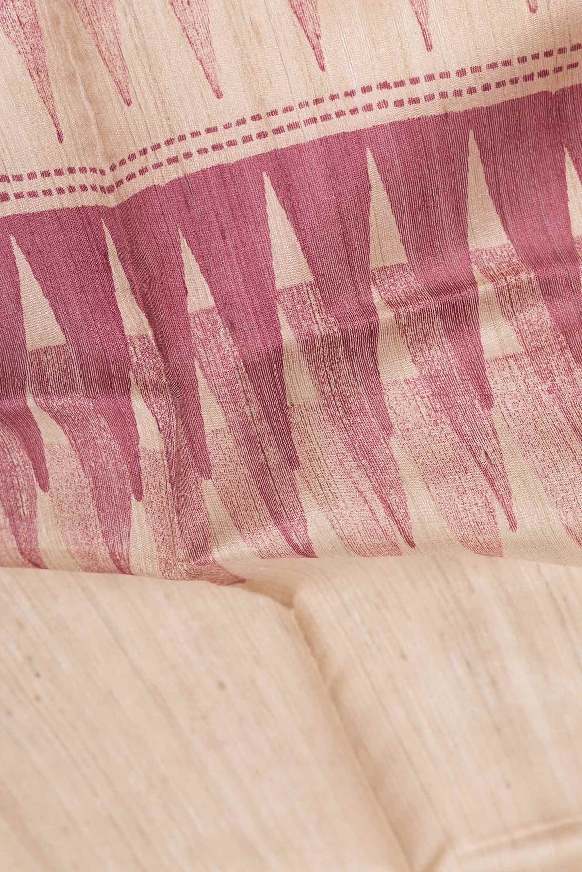 Close up of Maroon Dual Tone Tussar Silk Saree With Printed design on the body and Zari Border displaying folds