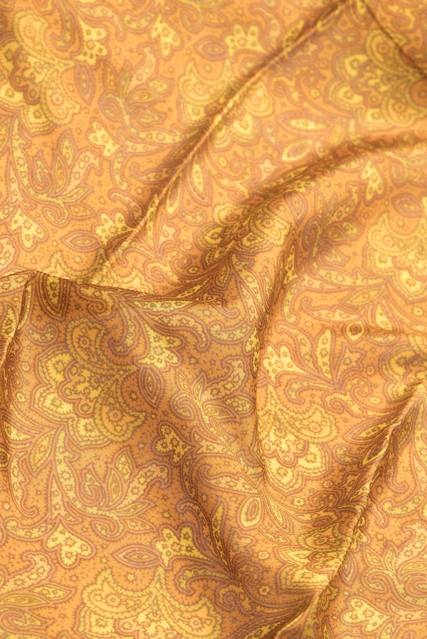 Close up of Mustard Dual Tone Mysore Crepe Saree with Printed design on the body and Zari Border.  displaying folds