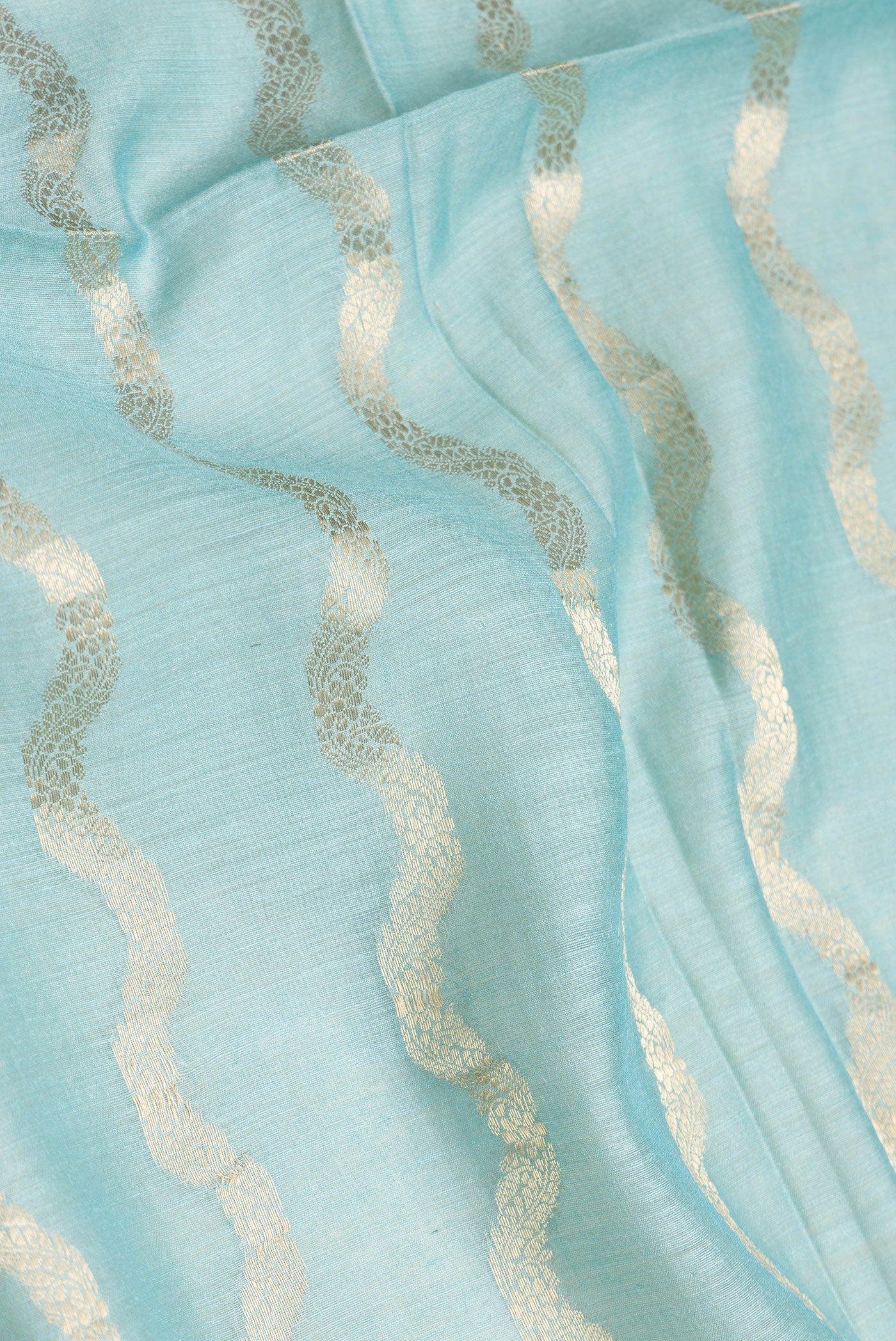 Close up of Sky Blue Dual Tone Tussar Silk Saree with Stripes on the body and Embroidery Border.  displaying folds