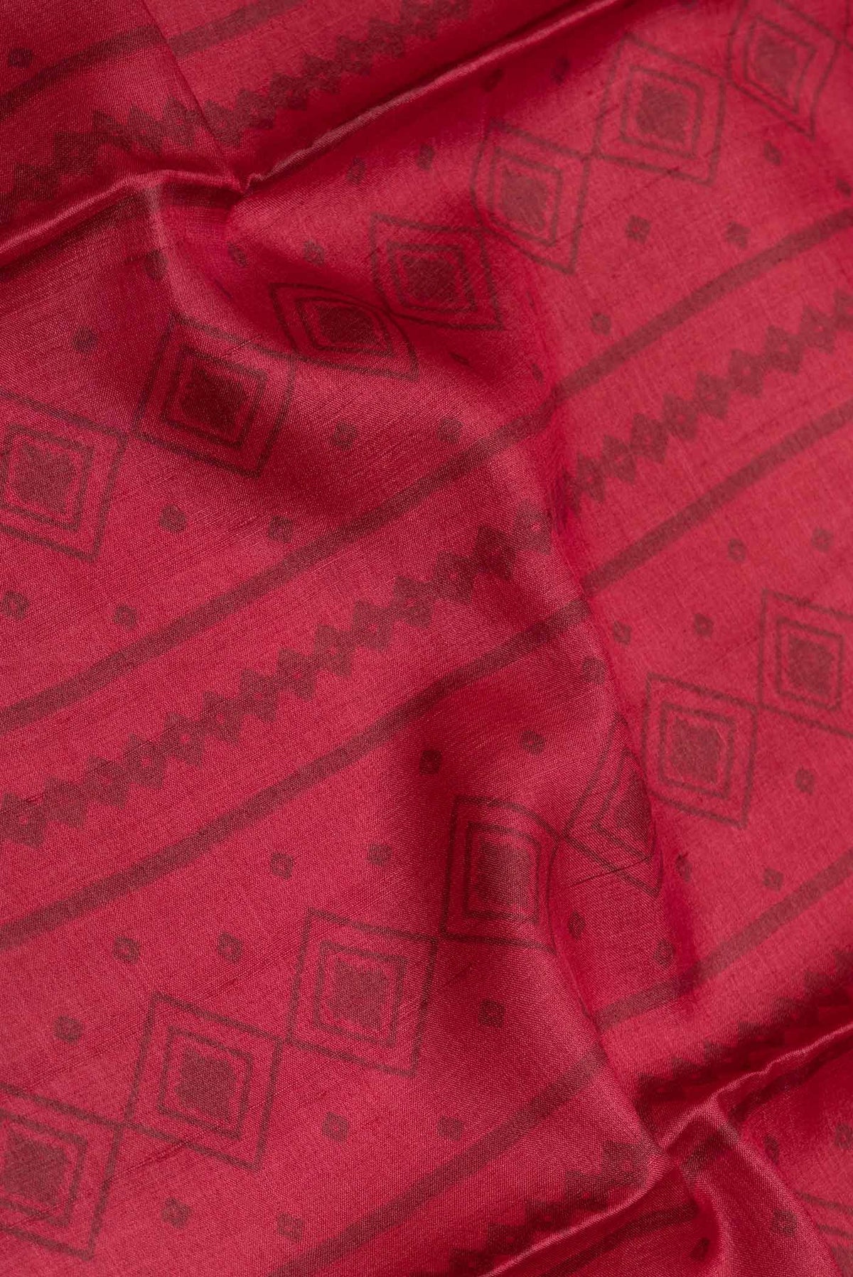 Close up of Red Dual Tone Tussar Saree with Printed design on the body and Printed Border displaying folds