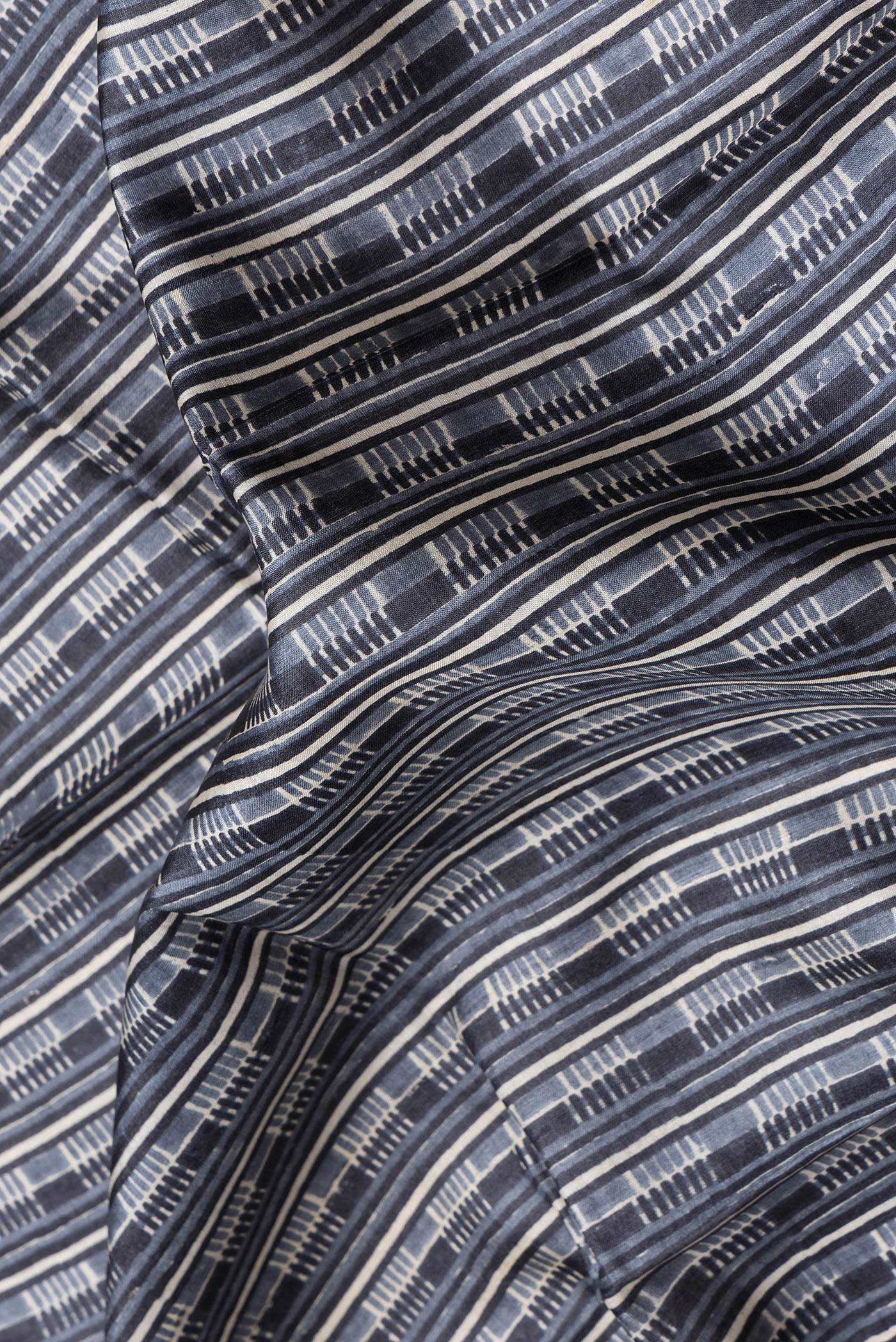 Close up of Grey Dual Tone Tussar Silk Saree with Printed design on the body and Printed Border.  displaying folds