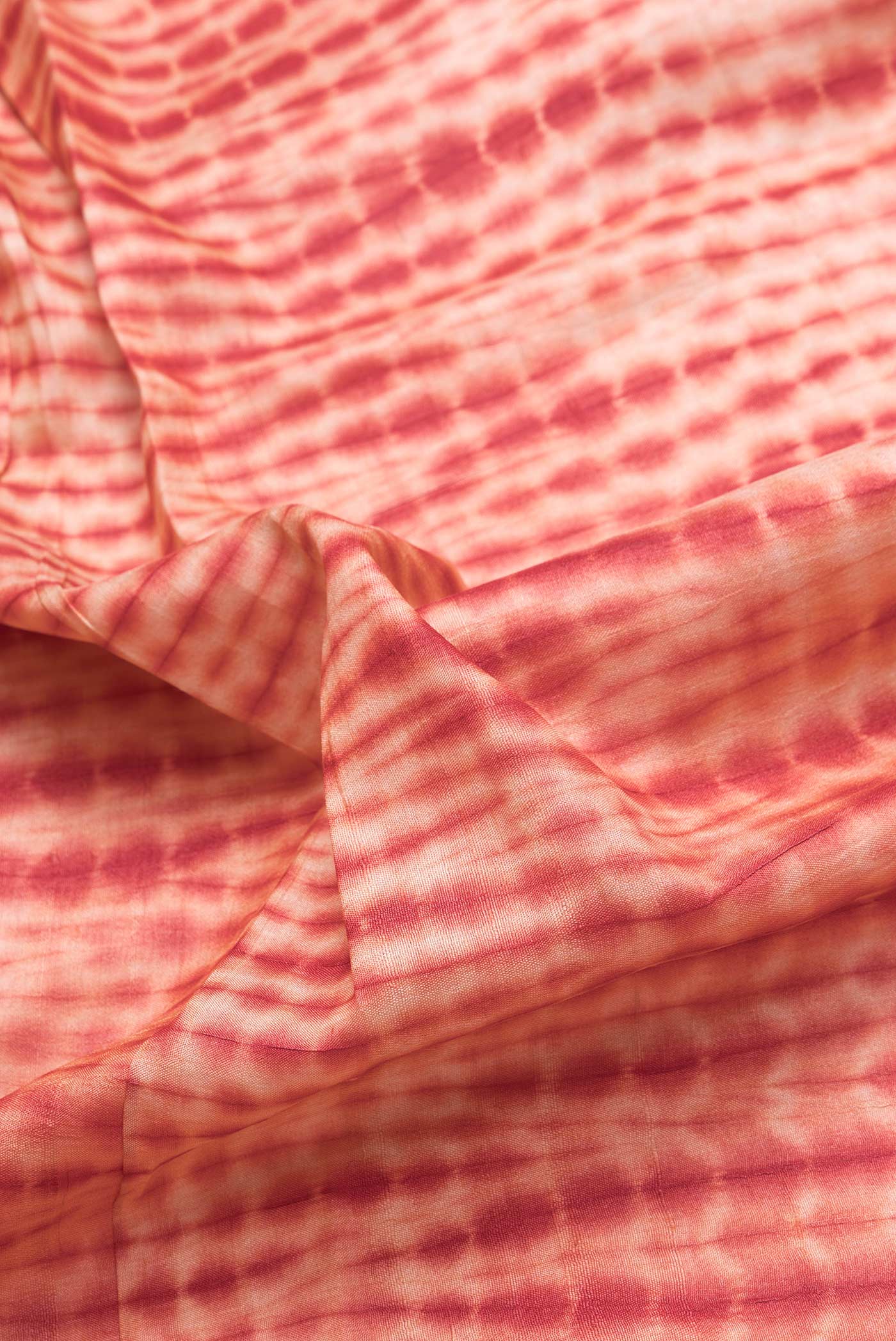 Close up of Golden Peach Dual Tone Tussar Silk Saree with Printed design on the body and Embroidery Border.  displaying folds