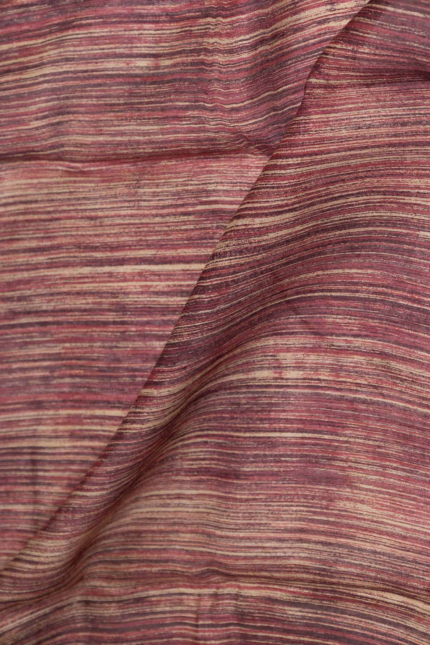 Close up of Maroon Dual Tone Tussar Saree with Printed design on the body and Printed Border displaying folds