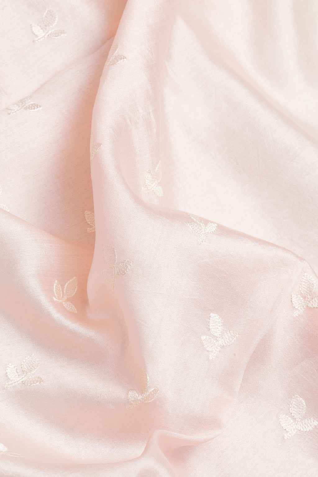 Close up of Rose Gold Dual Tone Tussar Silk Saree with Embroidery on the body and Zari Border.  displaying folds