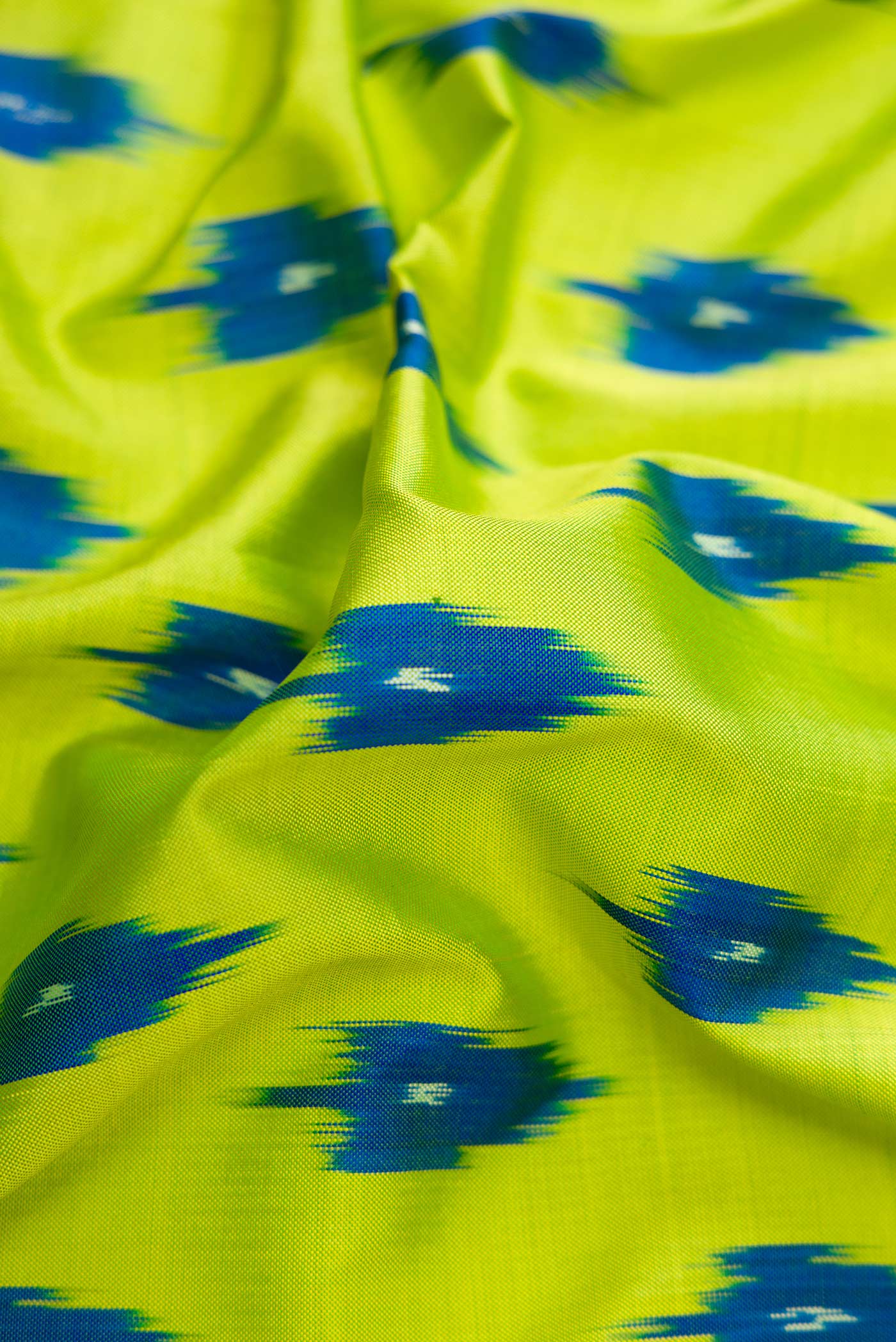 Close up of Parrot Green Dual Tone Double Ikat Saree with Ikat Print on the body and Ikat Border.  displaying folds