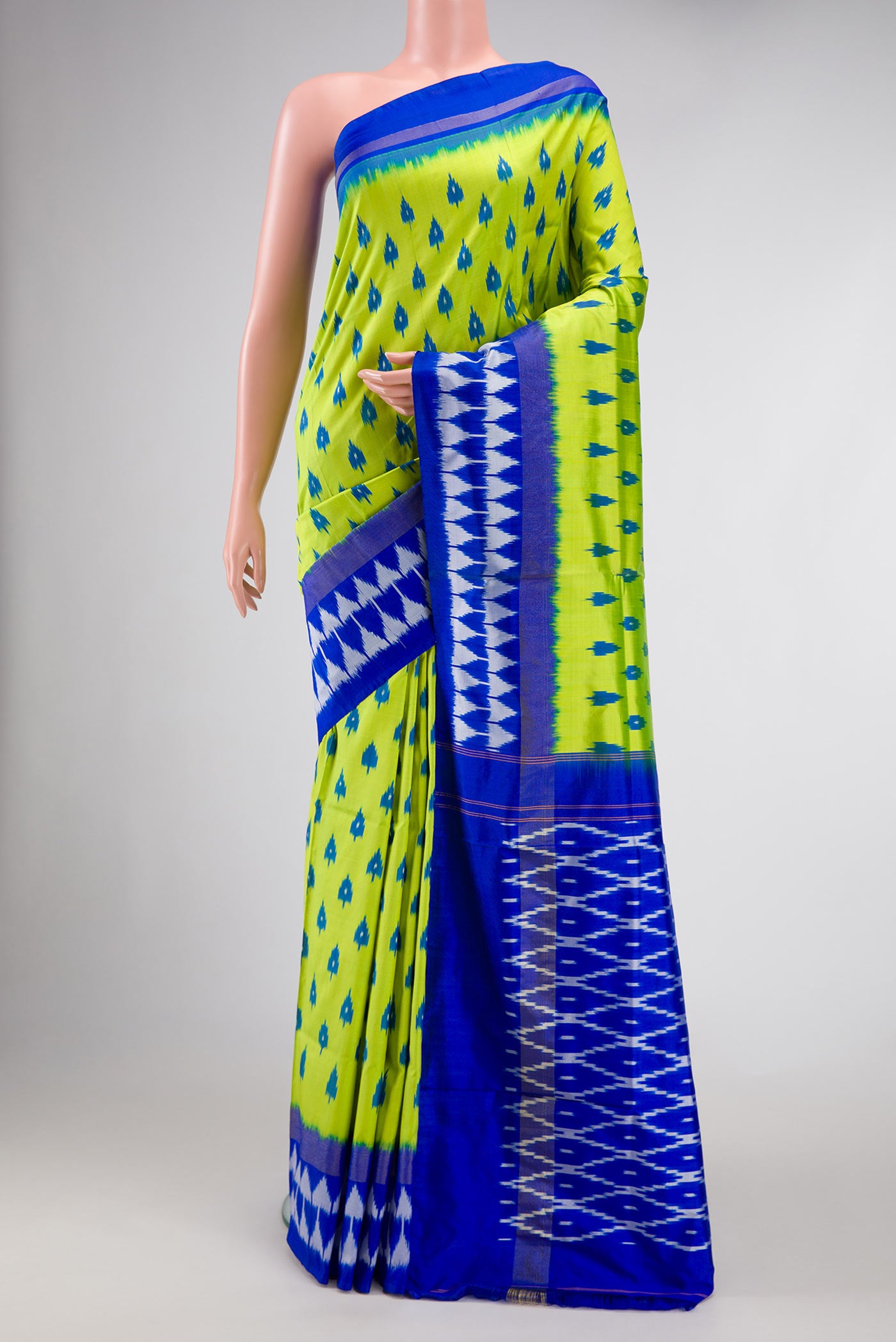 Parrot Green Dual Tone Double Ikat Saree with Ikat Print on the body and Ikat Border.  displayed on a mannequin