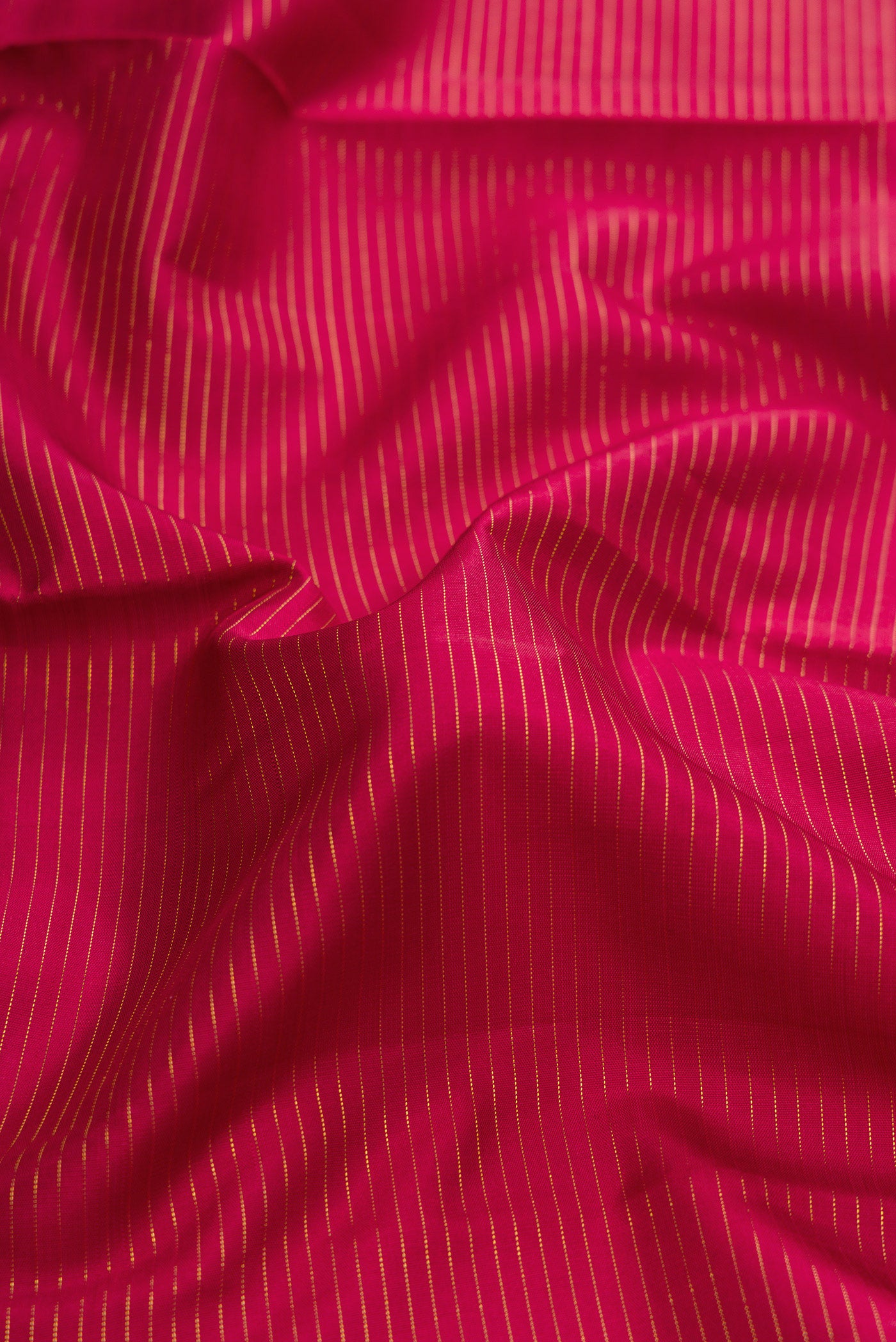 Close up of Maroon Kanchipuram Silk Saree with Stripes on the body and Zari Border.  displaying folds
