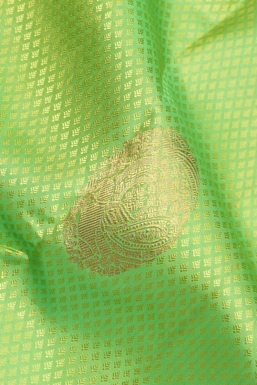 Close up of Pure Silk Parrot Green Kanchipuram Saree with Jacquard With Zari Butta on the body and Zari Border.  displaying folds