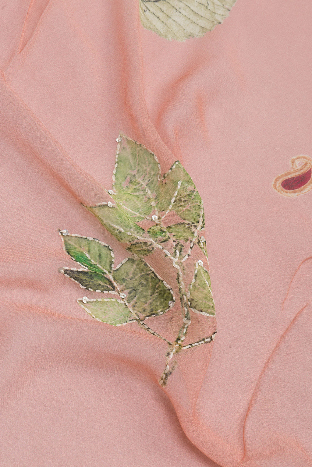 Close up of Peach Georgette Saree with Embroidery on the body and Embroidery Border.  displaying folds