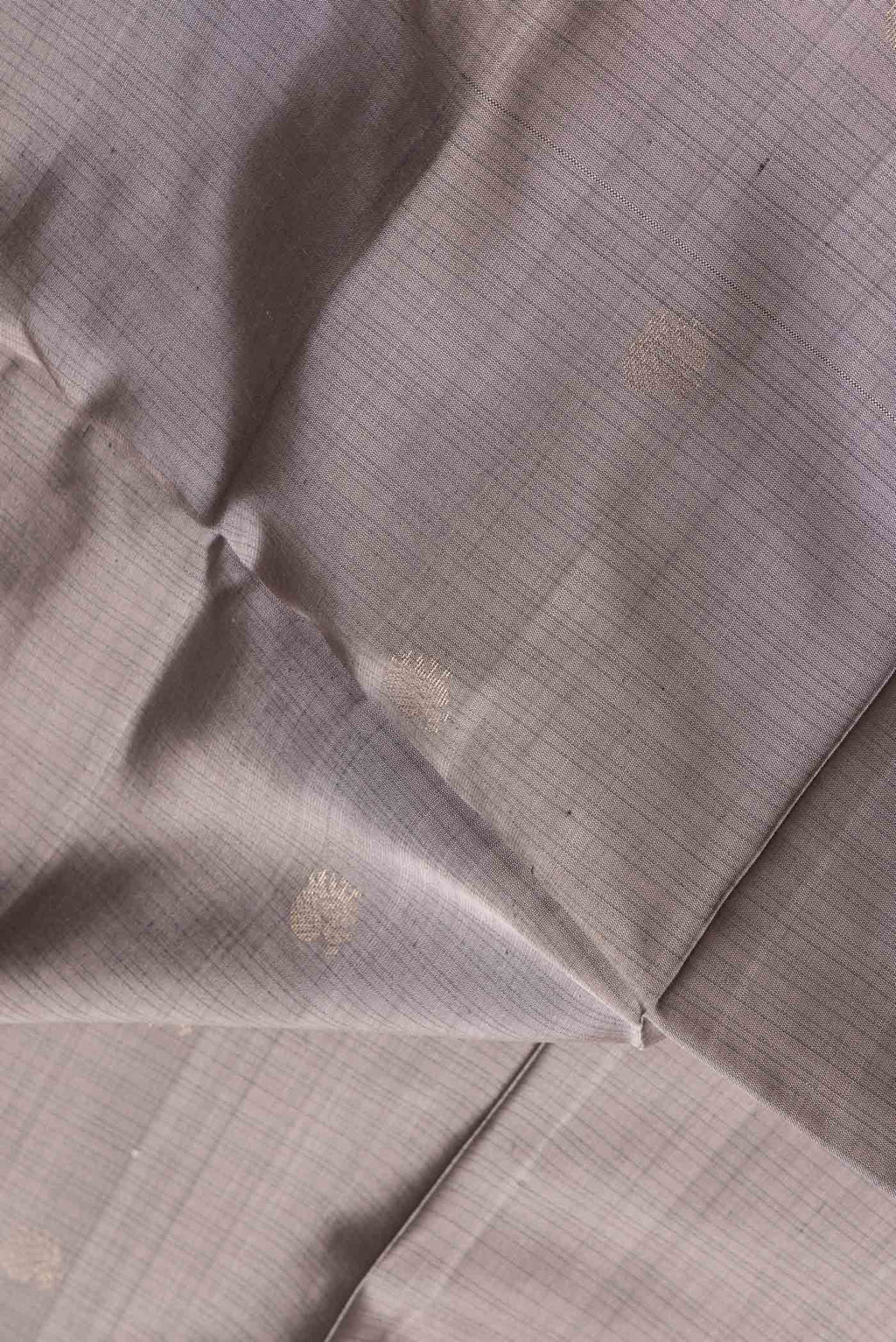 Close up of Grey Dual Tone Soft Silk Saree with Zari Butta on the body and Fancy Border.  displaying folds