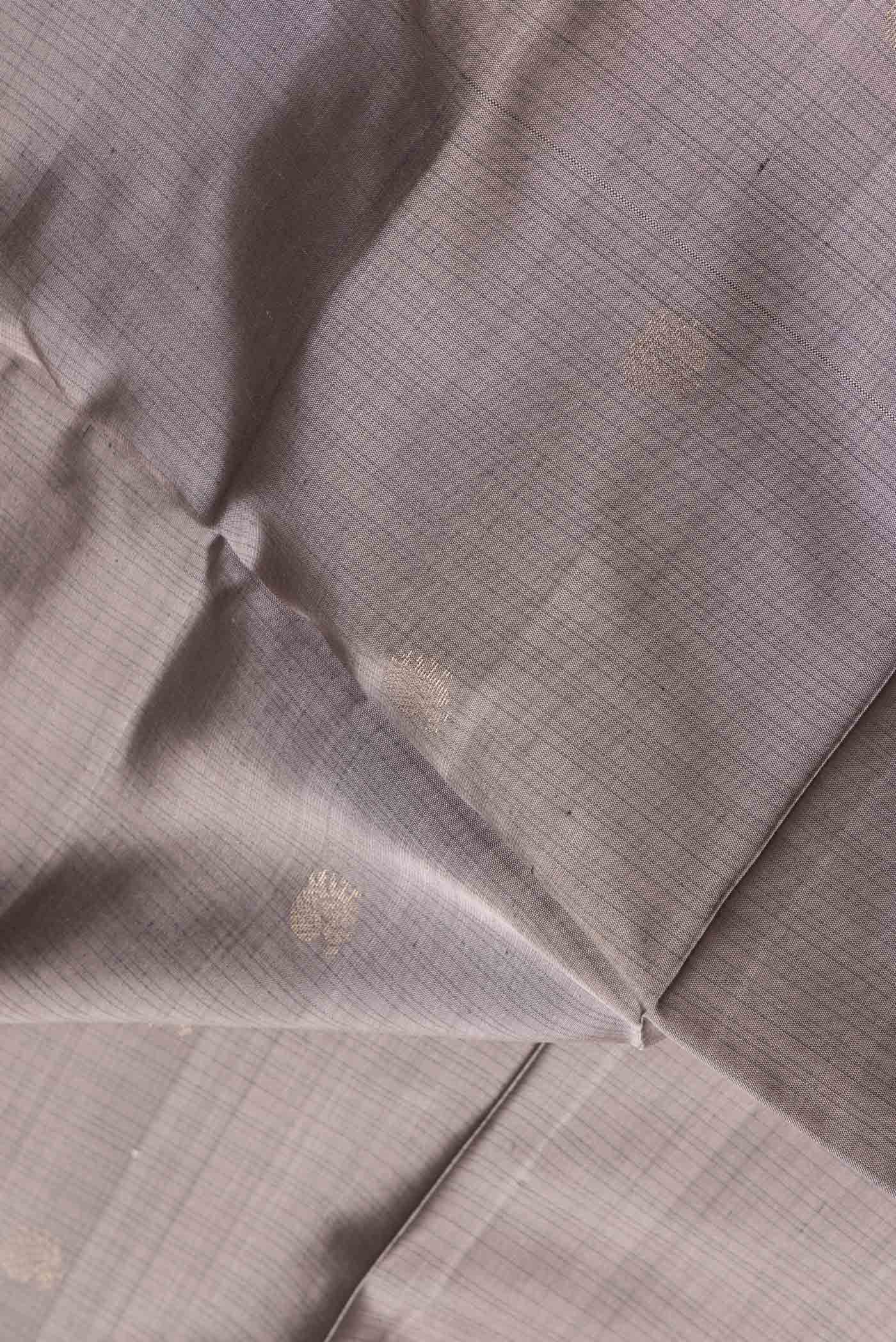Close up of Grey Dual Tone Soft Silk Saree with Zari Butta on the body and Fancy Border.  displaying folds
