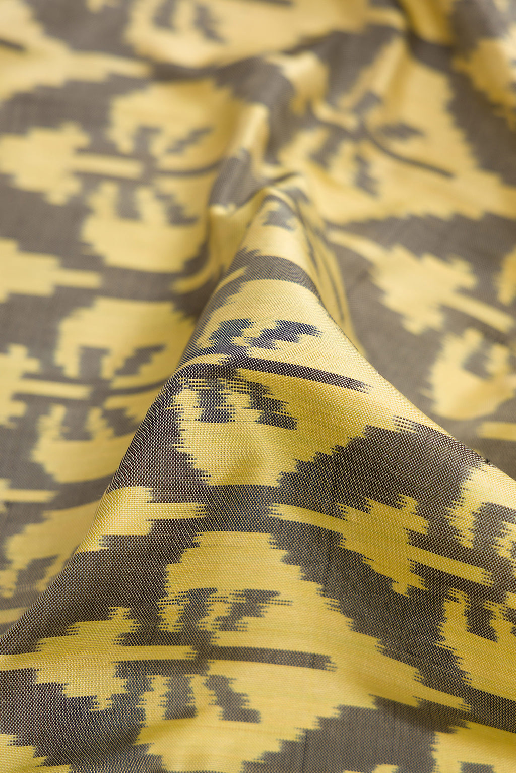 Close up of Sandal Dual Tone Double Ikat Saree with Ikat Print on the body and Thread Border.  displaying folds