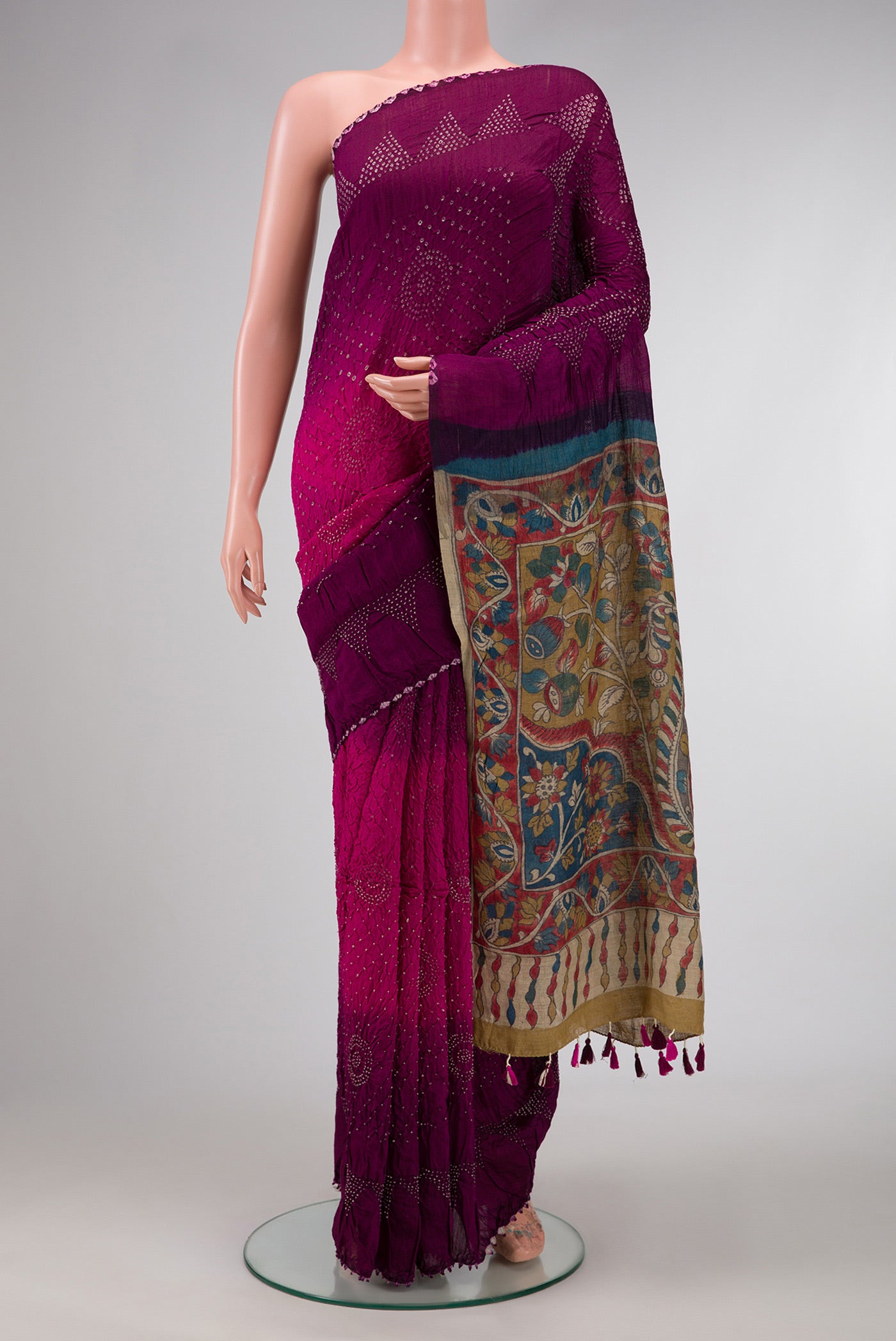 Magenta and Purple Color Bandhani Silk Saree with Bandhani Print on the body and Printed Border.  displayed on a mannequin
