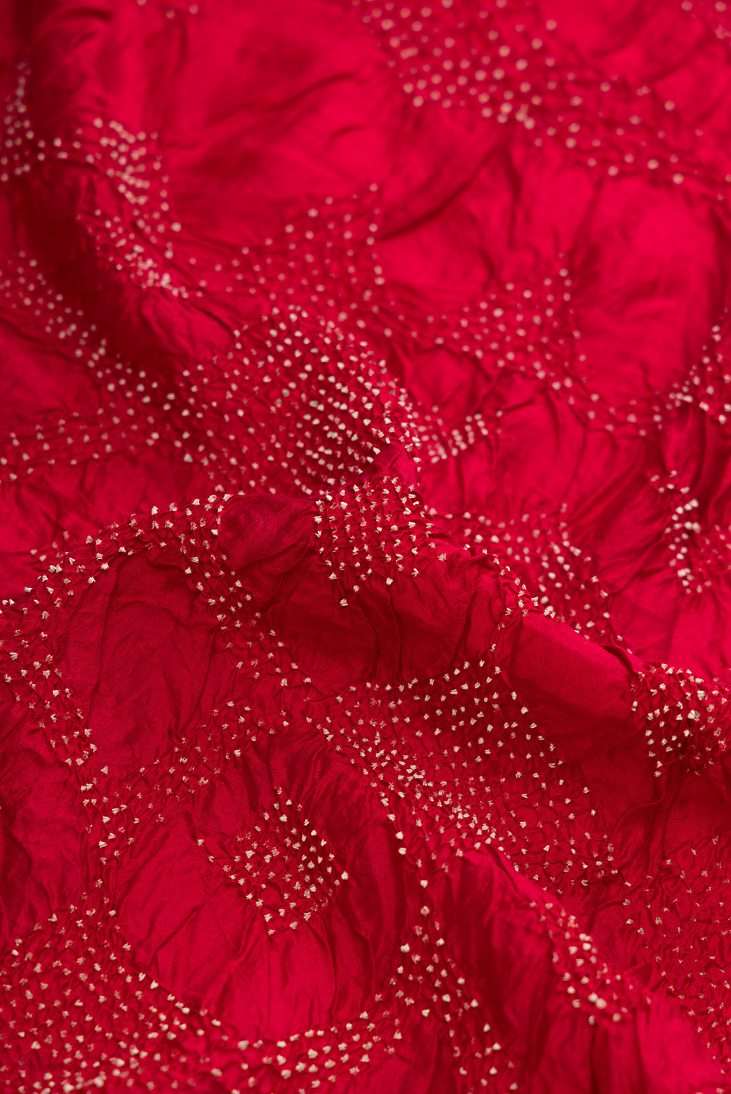 Close up of Maroon Dual Tone Bandhani Silk Saree with Bandhani Print on the body and Printed Border.  displaying folds