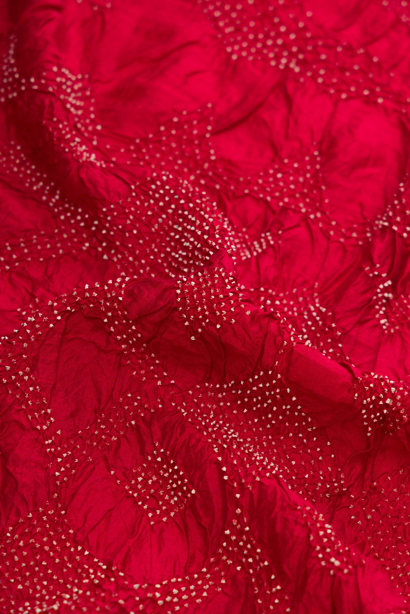 Close up of Maroon Dual Tone Bandhani Silk Saree with Bandhani Print on the body and Printed Border.  displaying folds