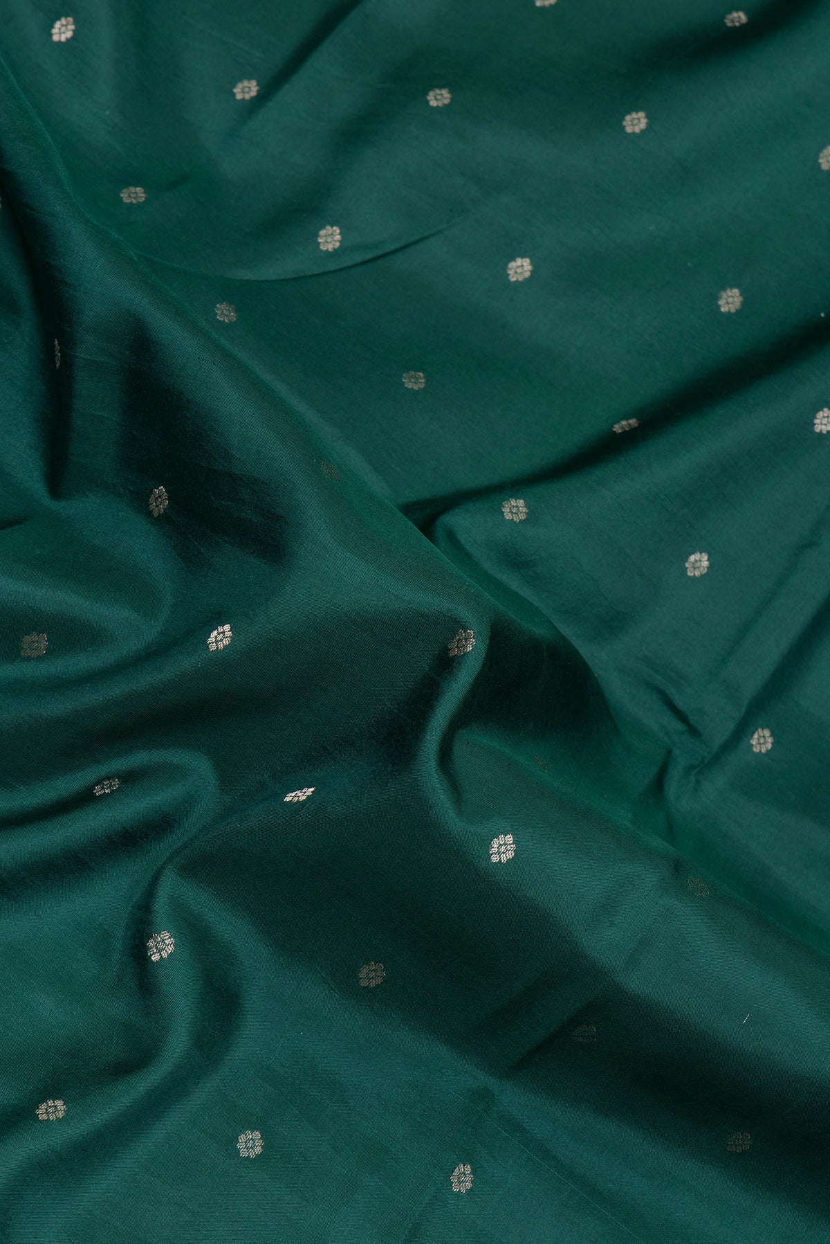 Close up of Bottle Green Kanjivaram Silk Saree with Zari Butta on the body and Fancy Border.  displaying folds