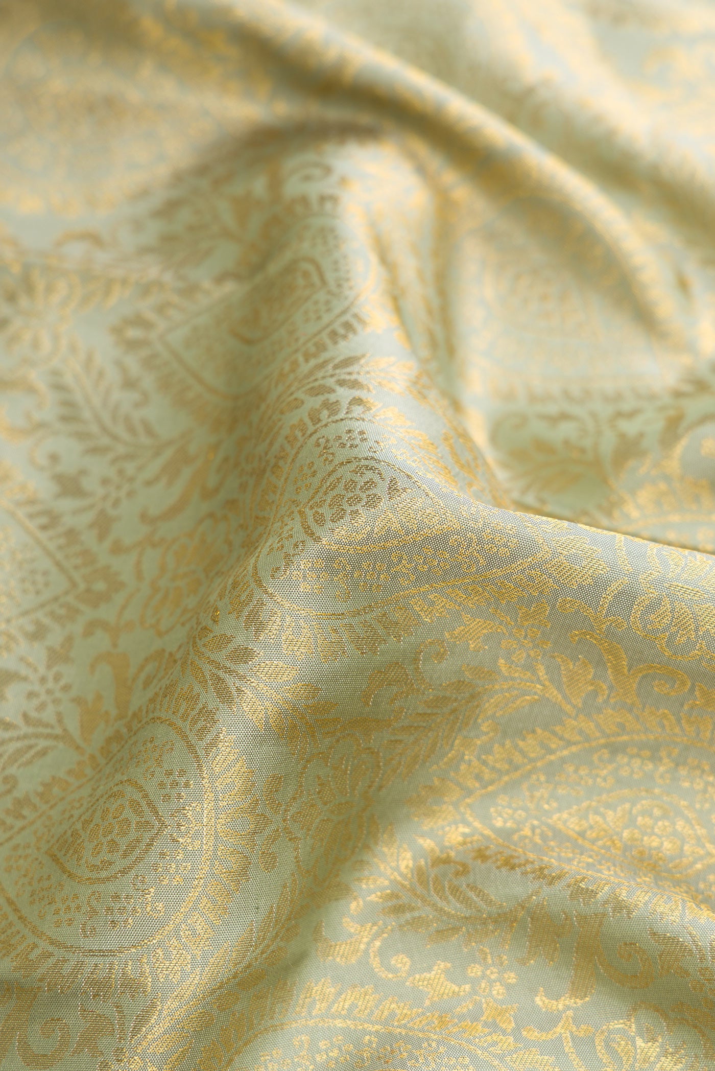 Close up of Pista Green Dual Tone Kanjivaram Silk Saree with Zari Brocade on the body and Zari Border.  displaying folds
