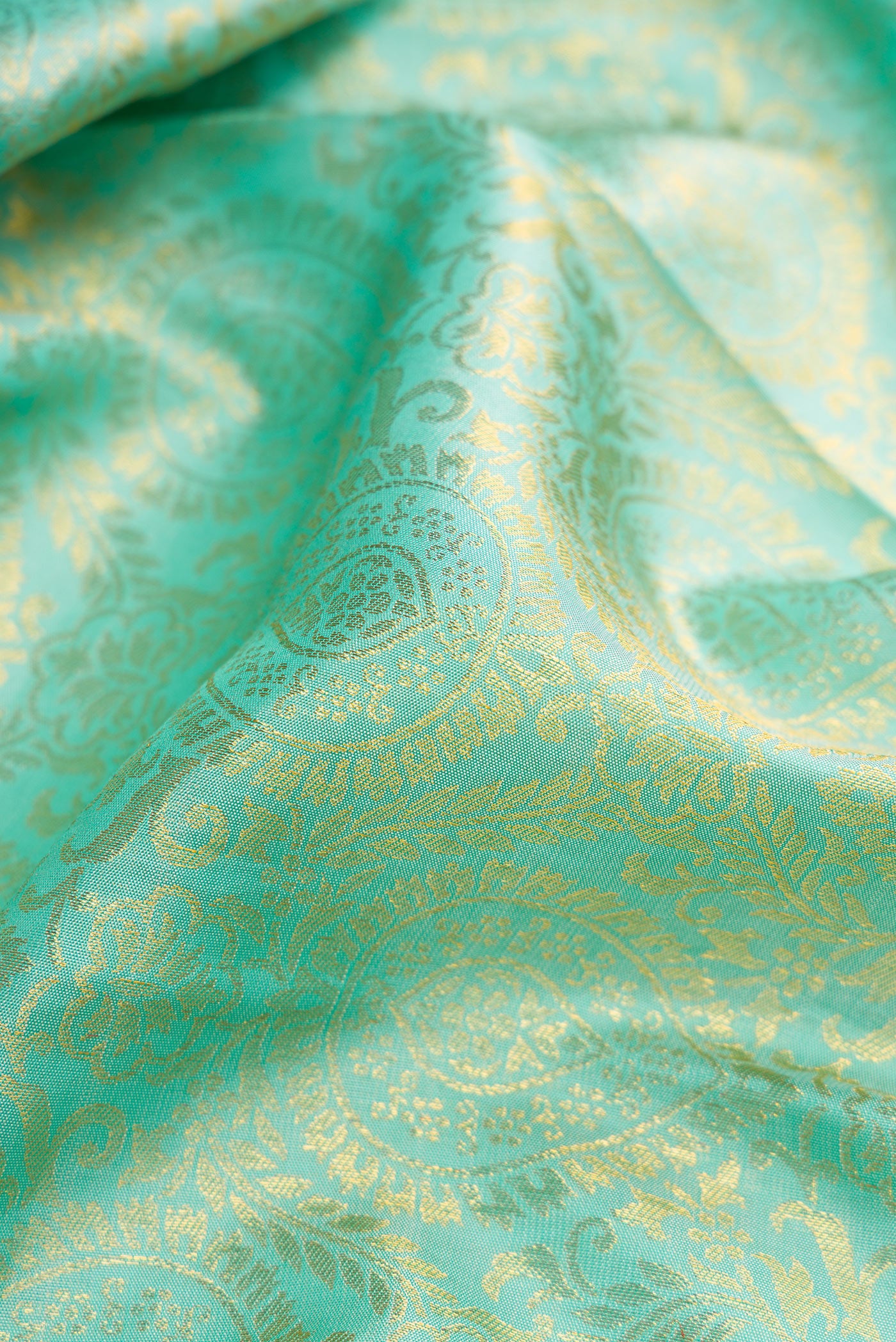 Close up of Sea Green Dual Tone Kanjivaram Silk Saree with Zari Brocade on the body and Zari Border.  displaying folds