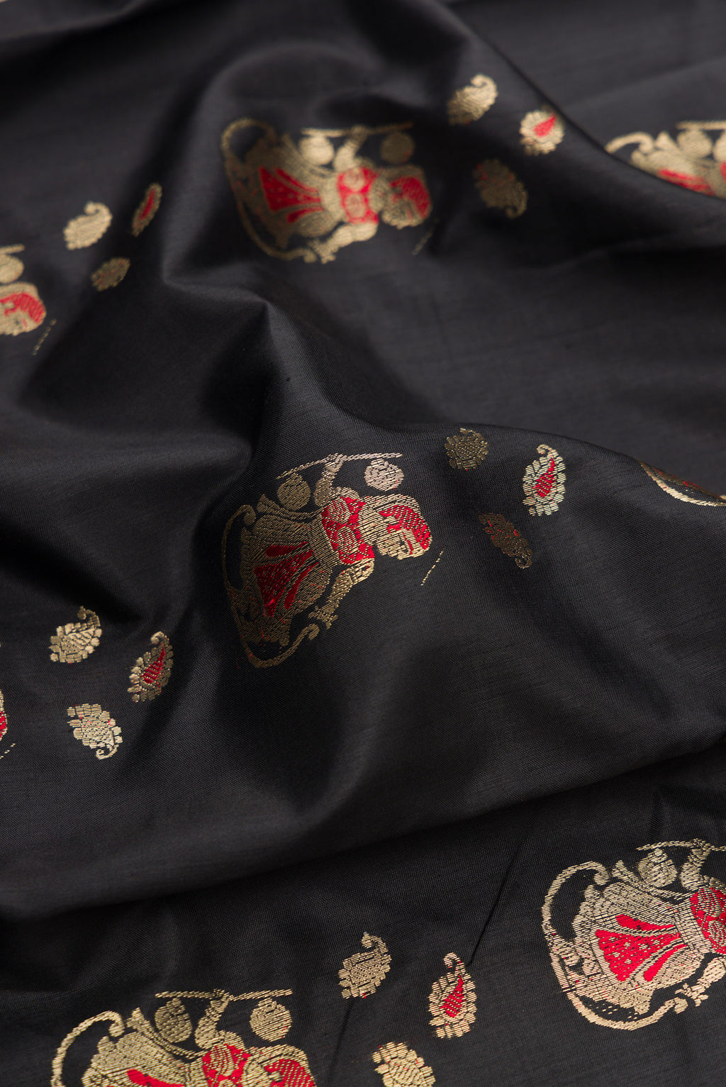 Close up of Pure Silk Black Baluchari Saree with Zari And Thread Butta on the body and Fancy Border.  displaying folds