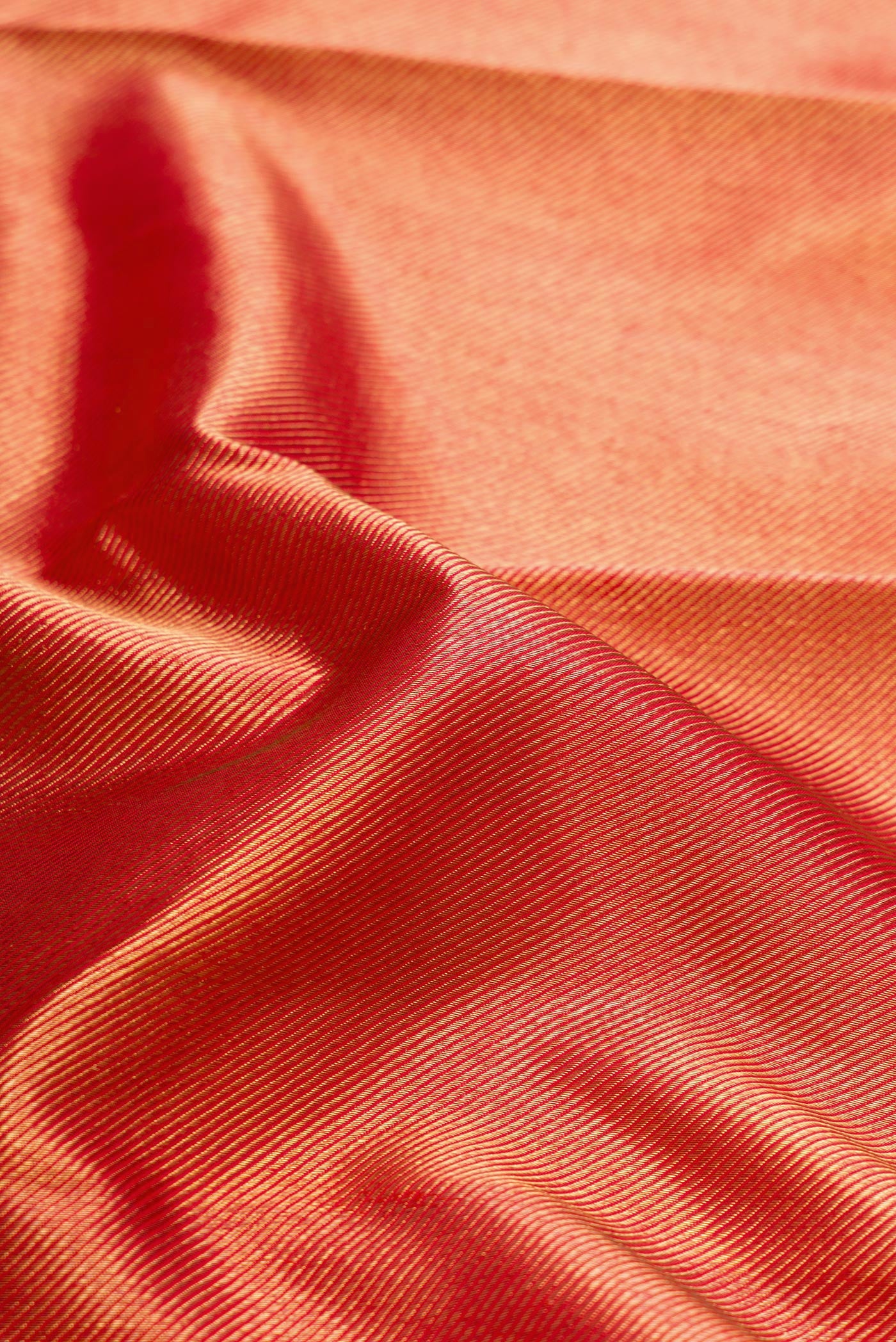 Close up of Pure Silk Pure Zari Red Dual Tone Kanjivaram Saree with Zari Brocade on the body and Zari Border.  displaying folds