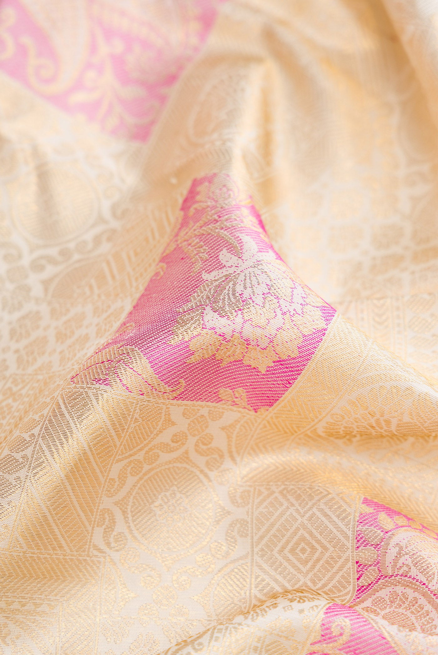 Close up of Off White Dual Tone Kanchipuram Silk Saree with Zari Brocade on the body and Zari Border.  displaying folds