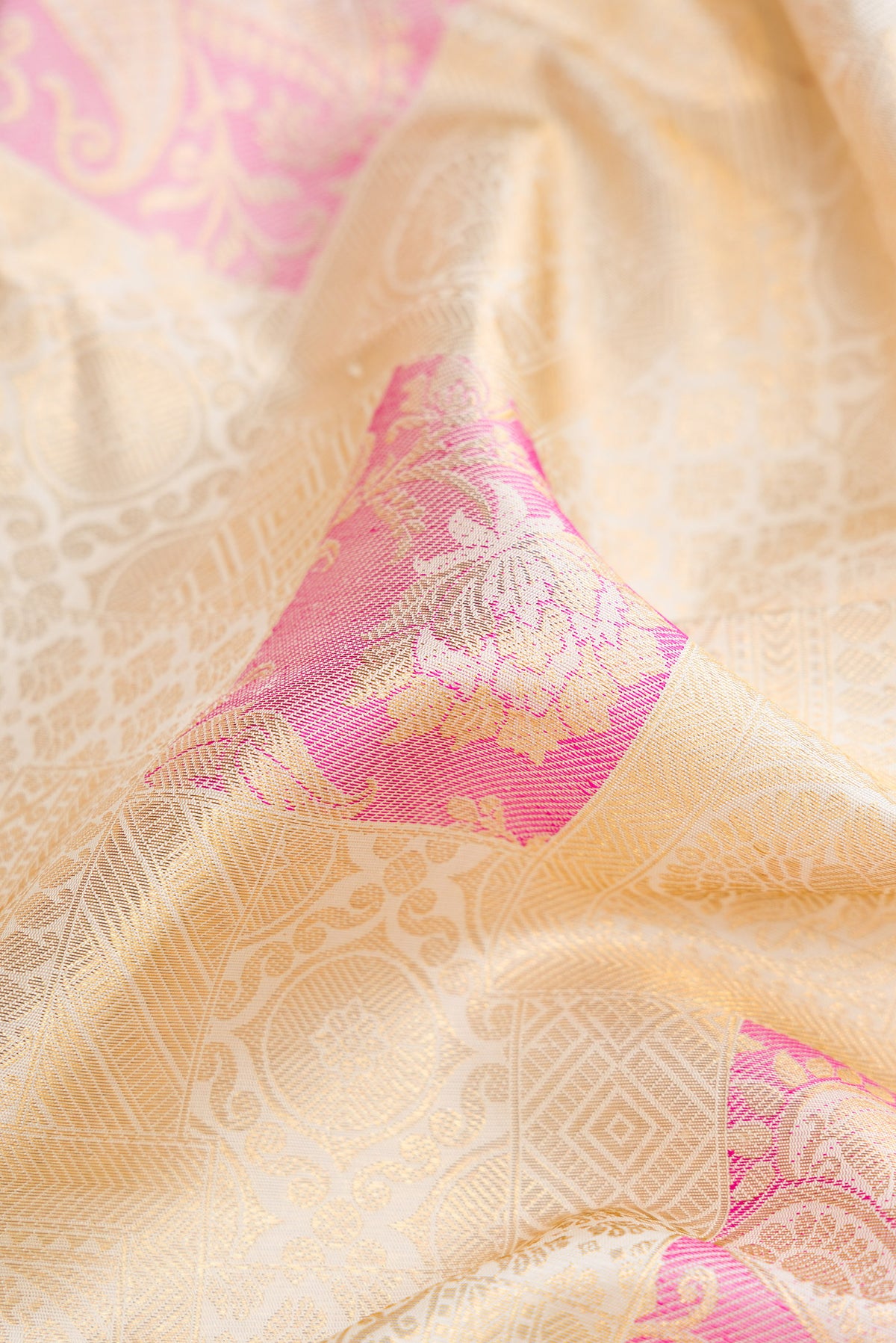 Close up of Off White Dual Tone Kanchipuram Silk Saree with Zari Brocade on the body and Zari Border.  displaying folds