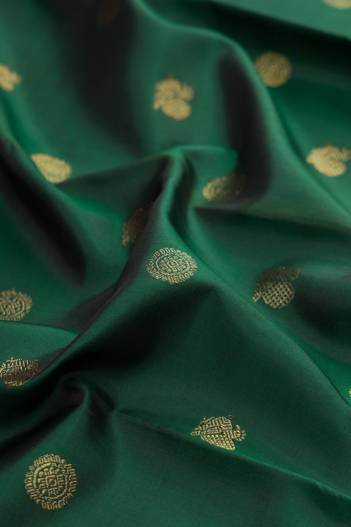 Close up of Pure Silk Pure Zari Bottle Green Kanjivaram Saree with Zari Butta on the body and Paithani Border.  displaying folds