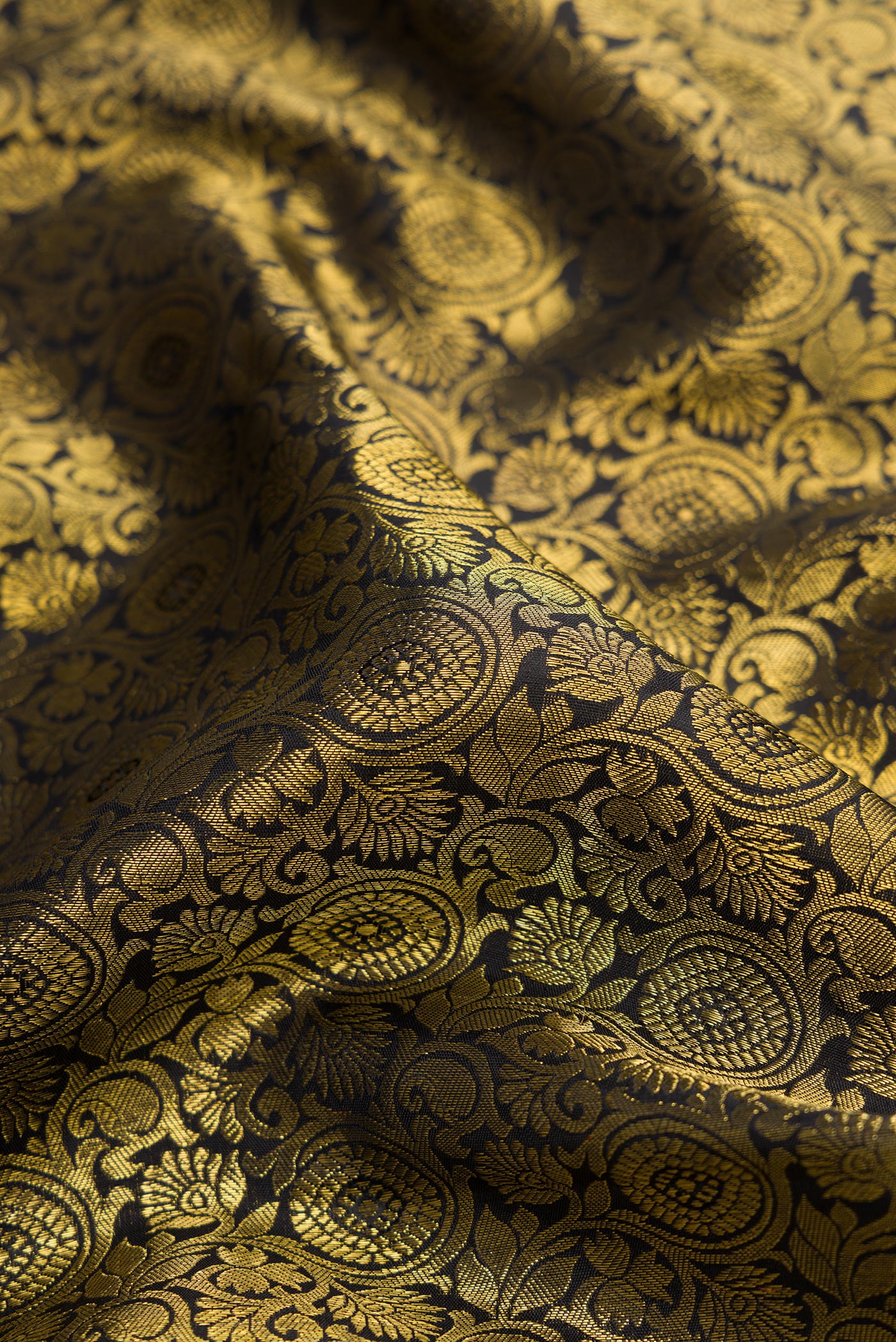 Close up of Pure Silk Pure Zari Black Dual Tone Kanjivaram Saree with Zari Brocade on the body and Zari Border.  displaying folds