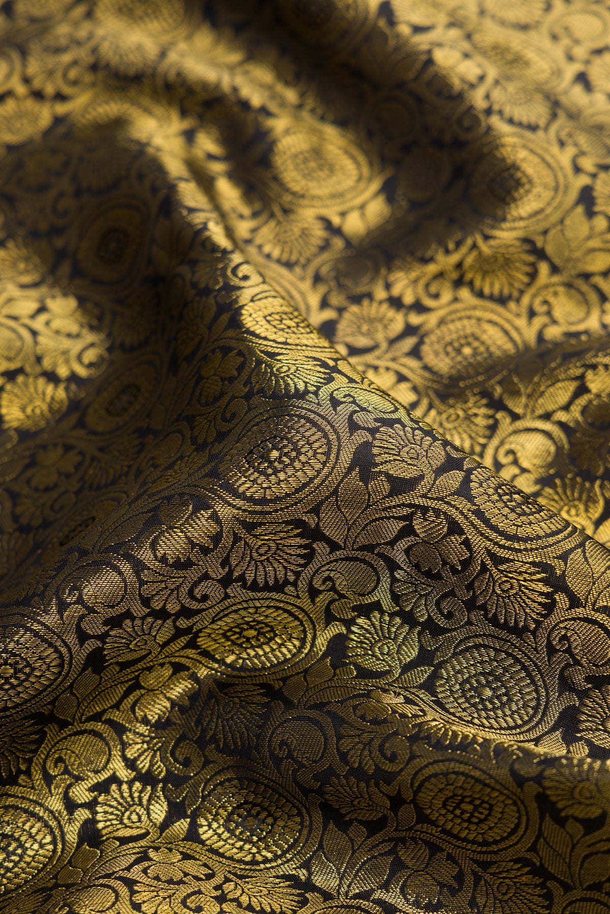 Close up of Pure Silk Pure Zari Black Dual Tone Kanjivaram Saree with Zari Brocade on the body and Zari Border.  displaying folds