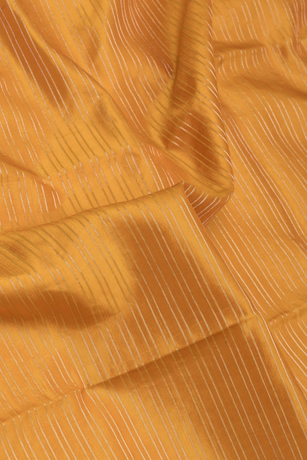 Close up of Mustard Kanjivaram Silk Saree with Stripes on the body and Fancy Border.  displaying folds