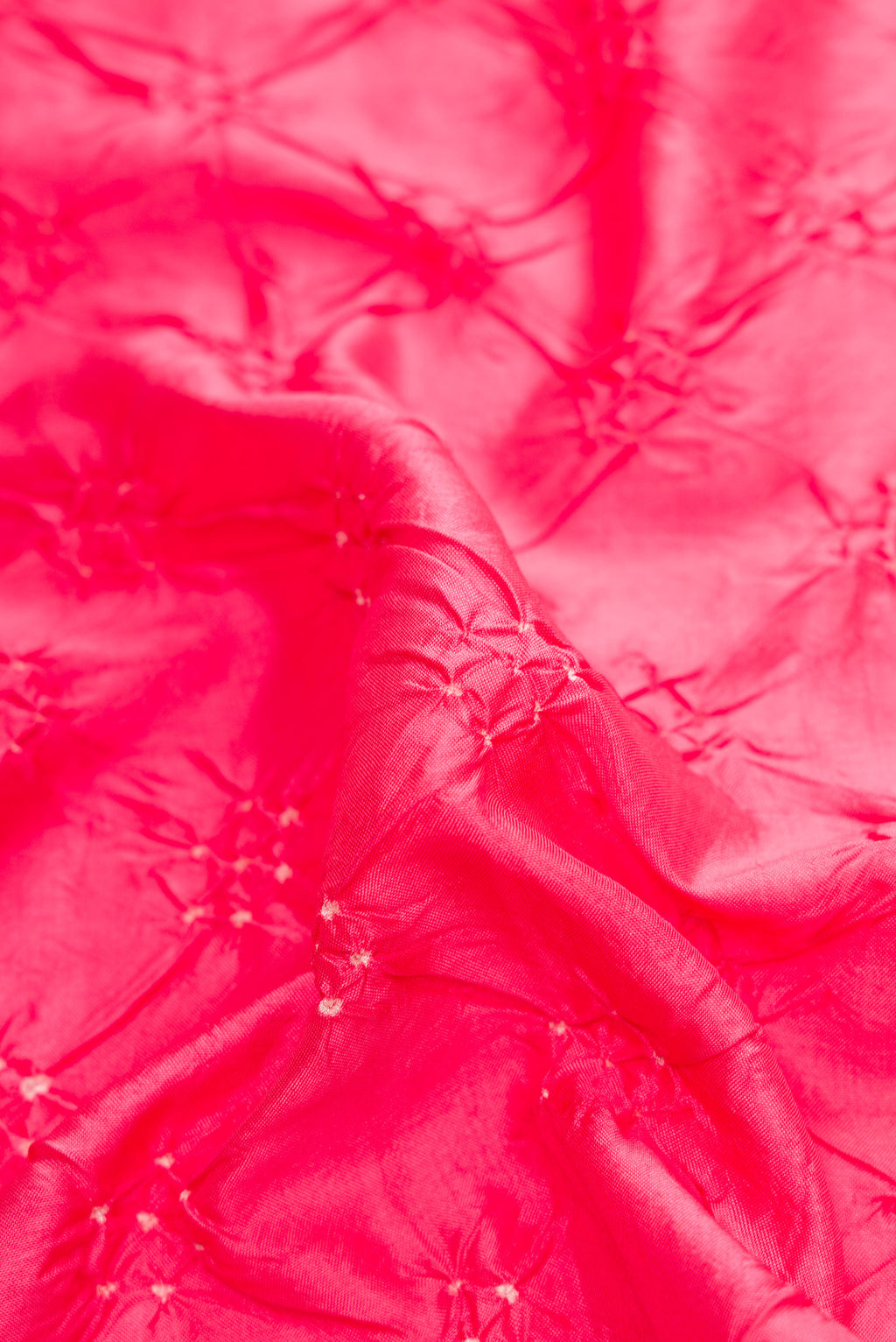 Close up of Pink Dual Tone Bandhani Silk Saree with Bandhani Print on the body and Zari Border.  displaying folds