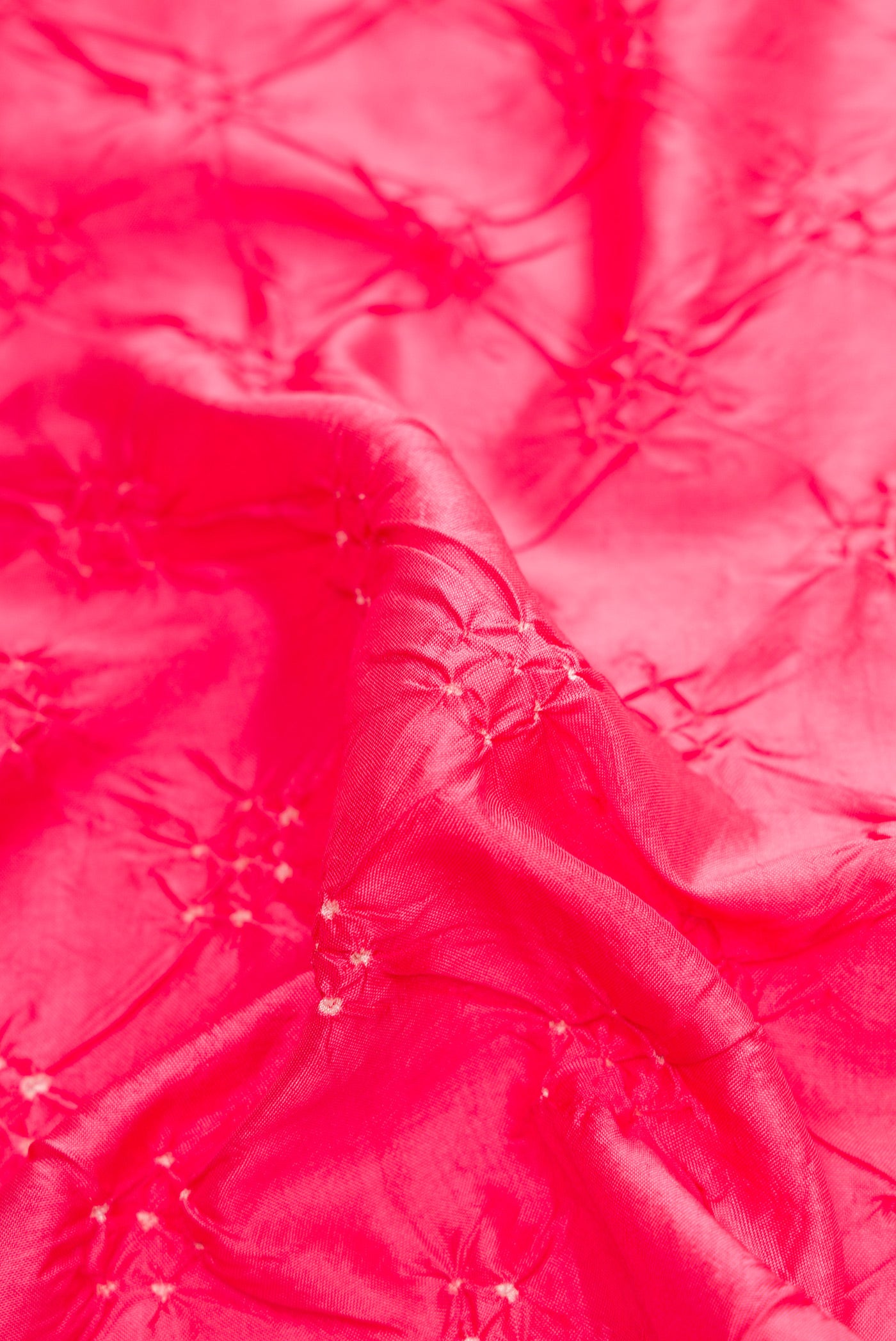 Close up of Pink Dual Tone Bandhani Silk Saree with Bandhani Print on the body and Zari Border.  displaying folds
