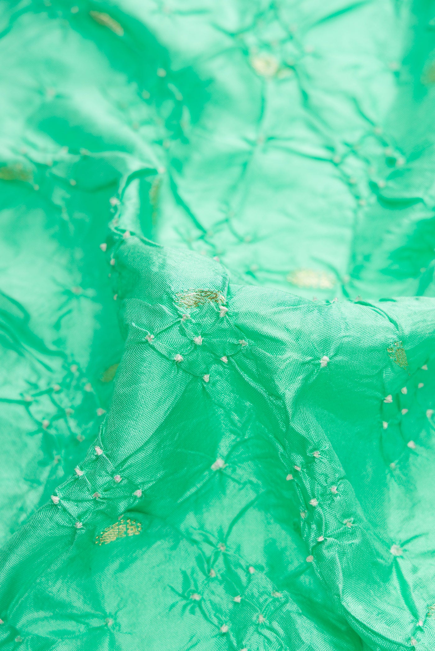 Close up of Sea Green Dual Tone Bandhani Silk Saree with Bandhani Print on the body and Zari Border.  displaying folds