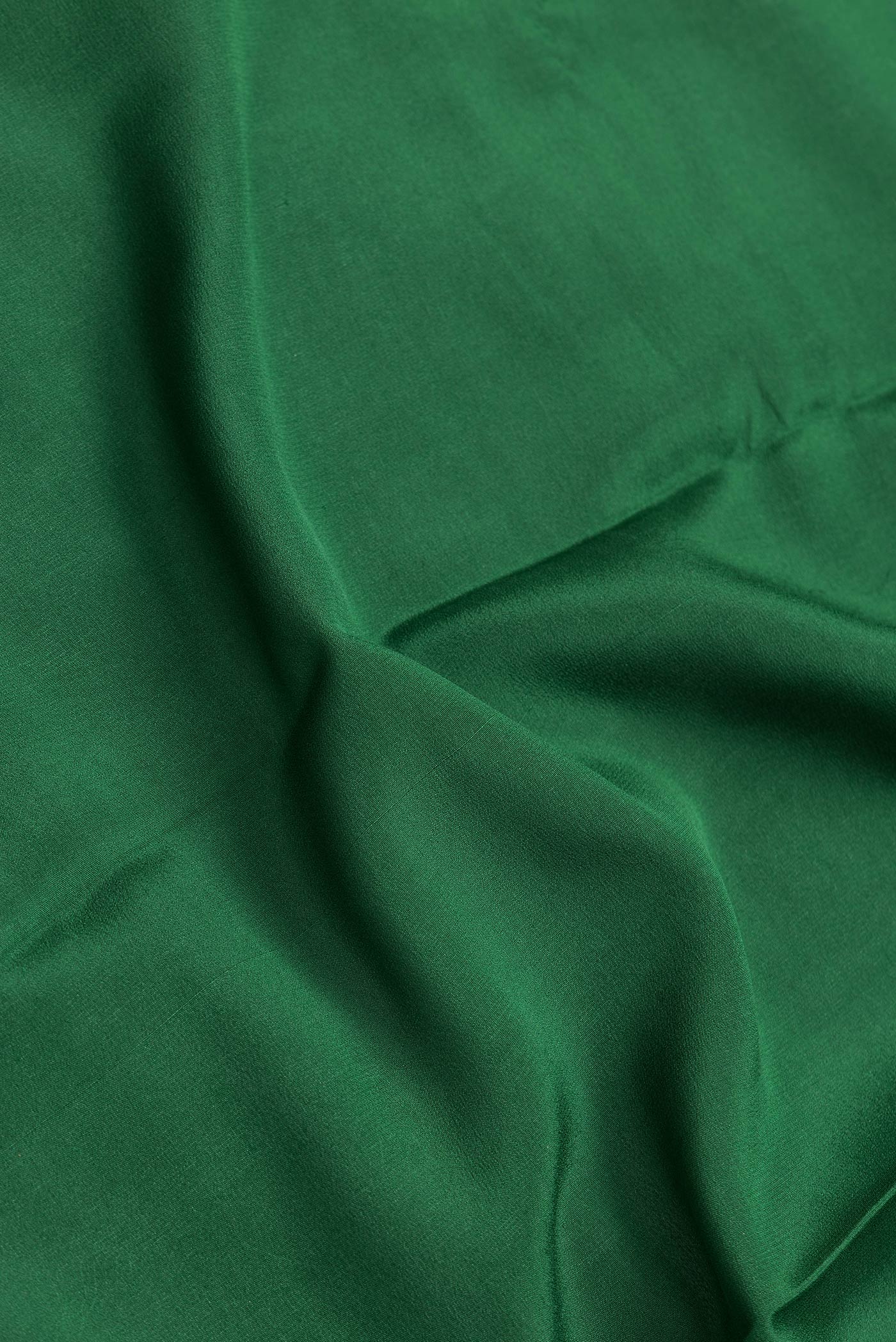 Close up of Bottle Green Dual Tone Mysore Georgette Saree with Plain Body and Zari Border.  displaying folds