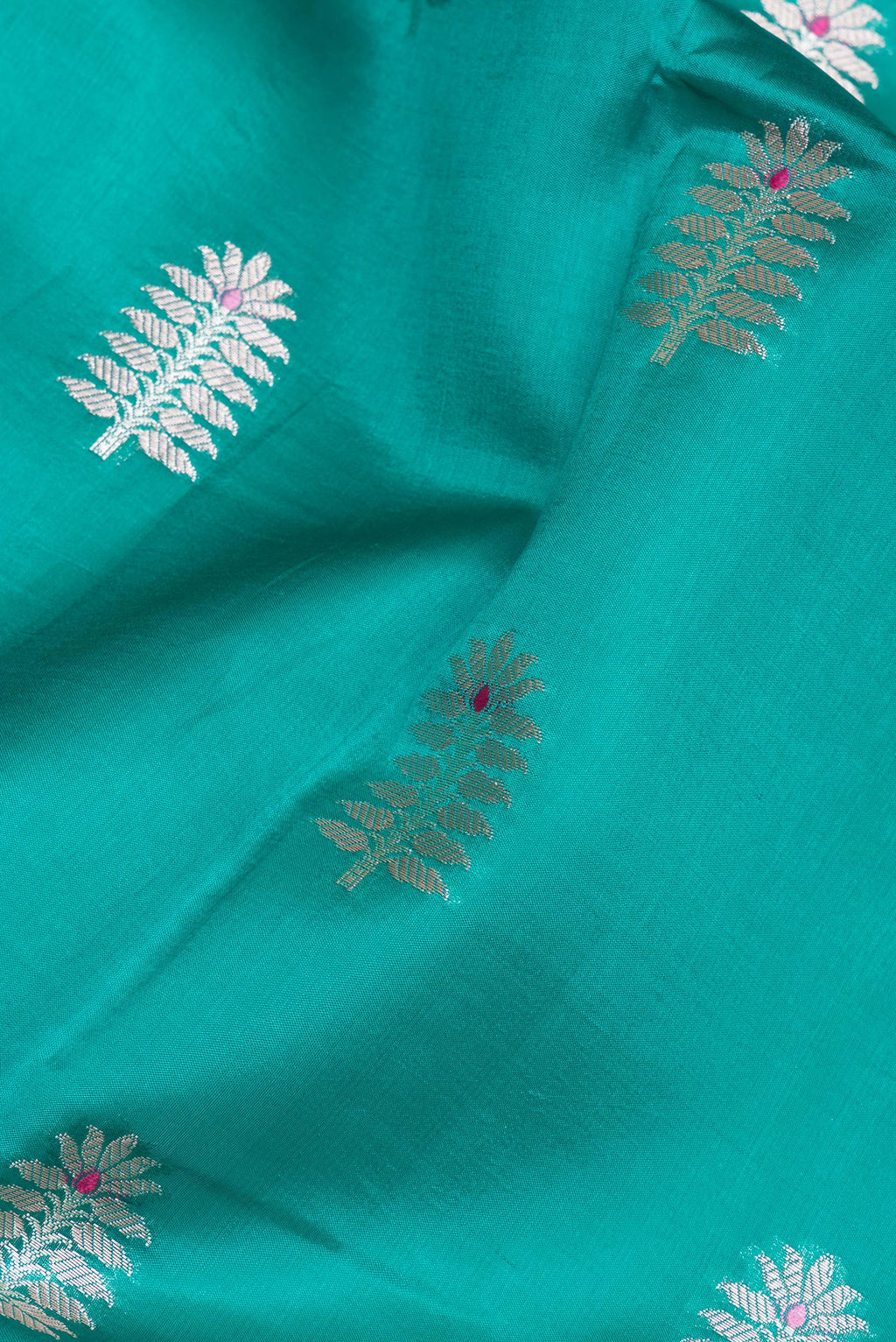 Close up of Green Tussar Silk Saree with Zari Butta on the body and Zari Border.  displaying folds
