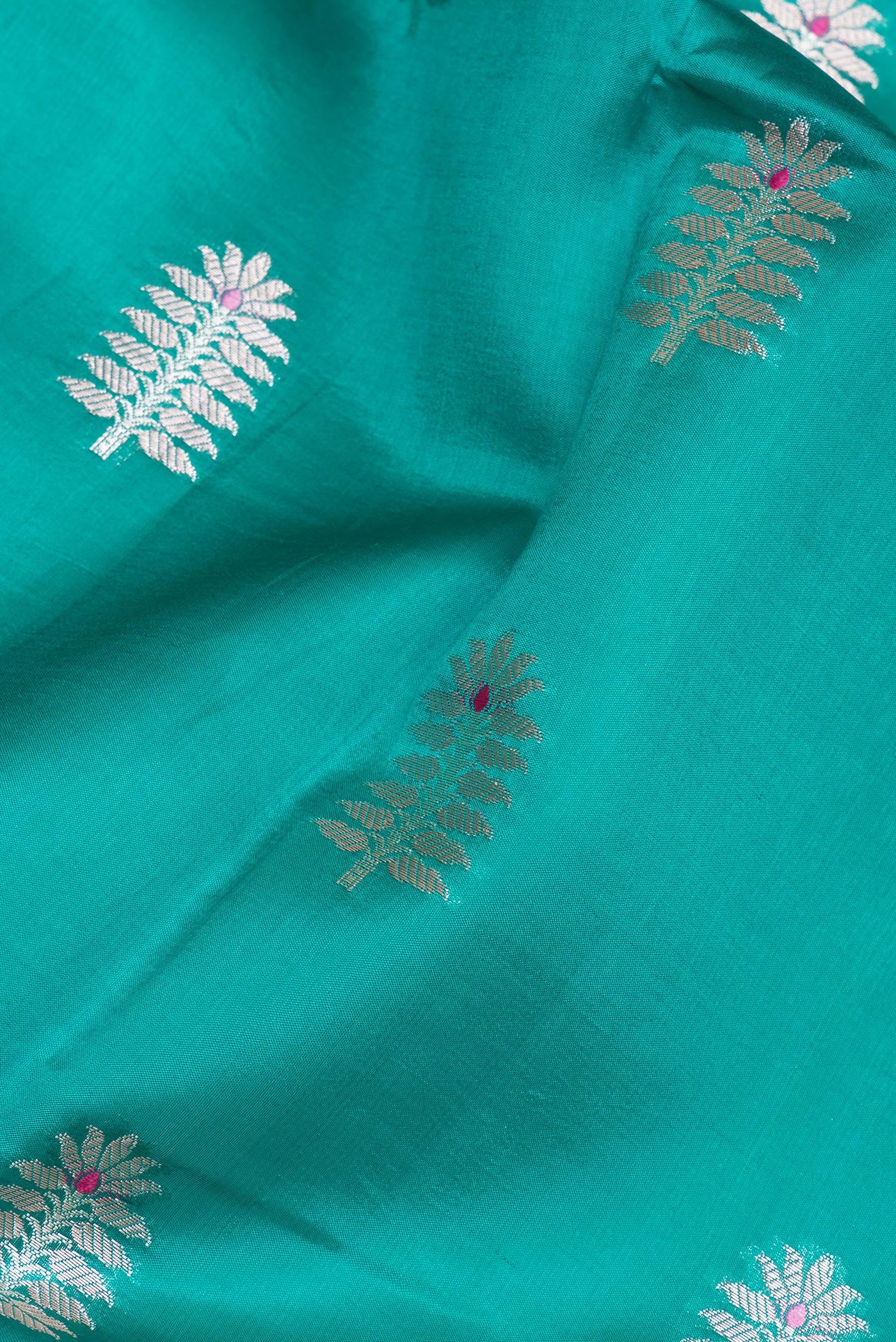 Close up of Green Tussar Silk Saree with Zari Butta on the body and Zari Border.  displaying folds