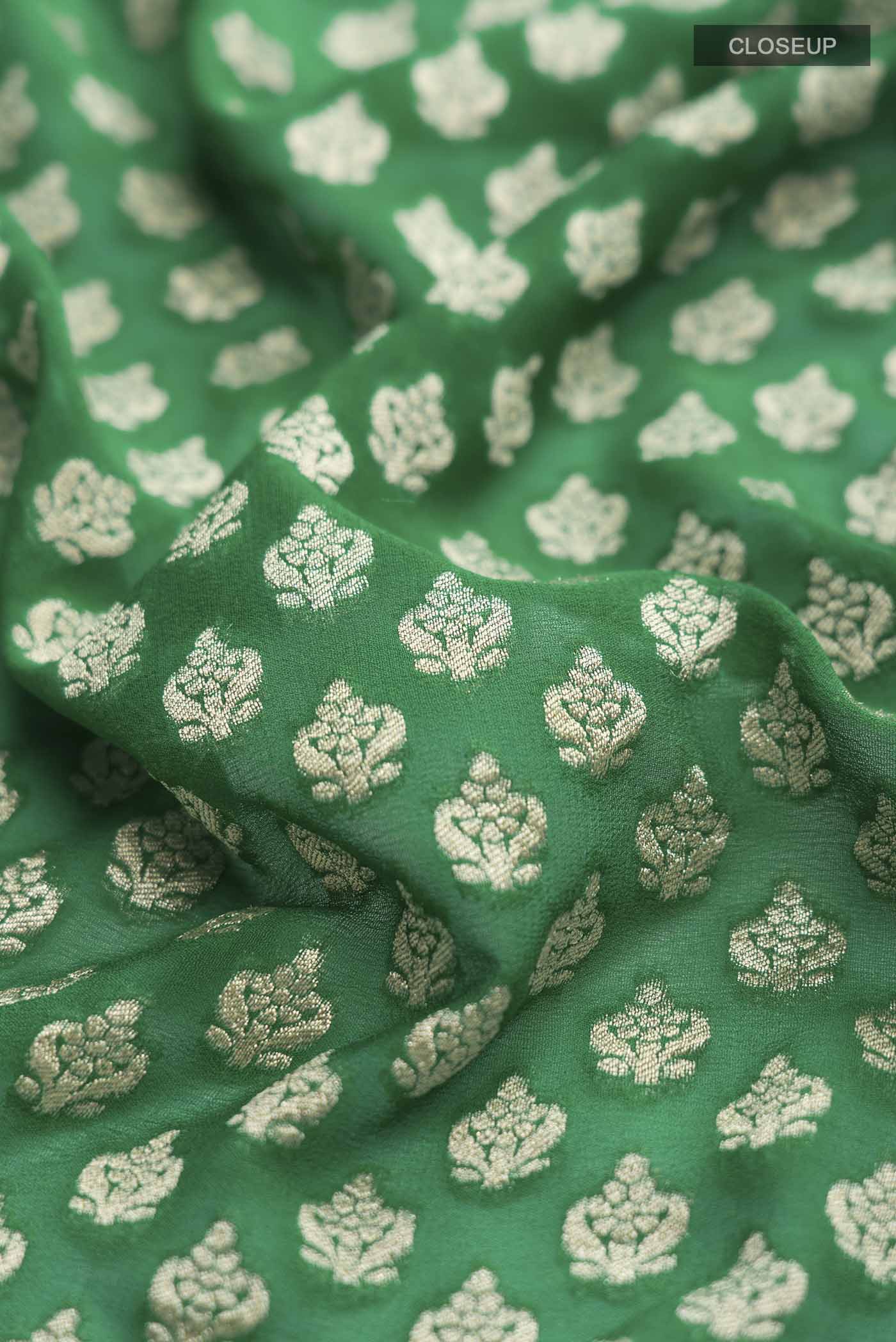 Close up of Green Banarasi Georgette Saree with Zari Butta on the body and Zari Border displaying folds