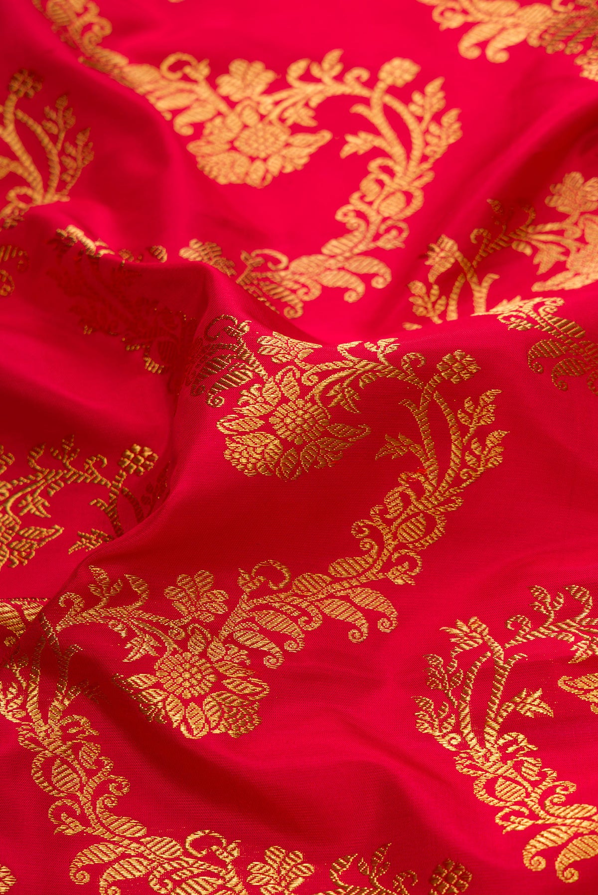Close up of Pure Silk Pure Zari Red Dual Tone Kanjivaram Saree with Zari Brocade on the body and Zari Border.  displaying folds
