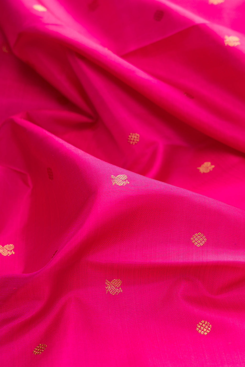 Close up of Pure Silk Pure Zari Pink Kanjivaram Saree with Zari Butta on the body and Zari Border.  displaying folds
