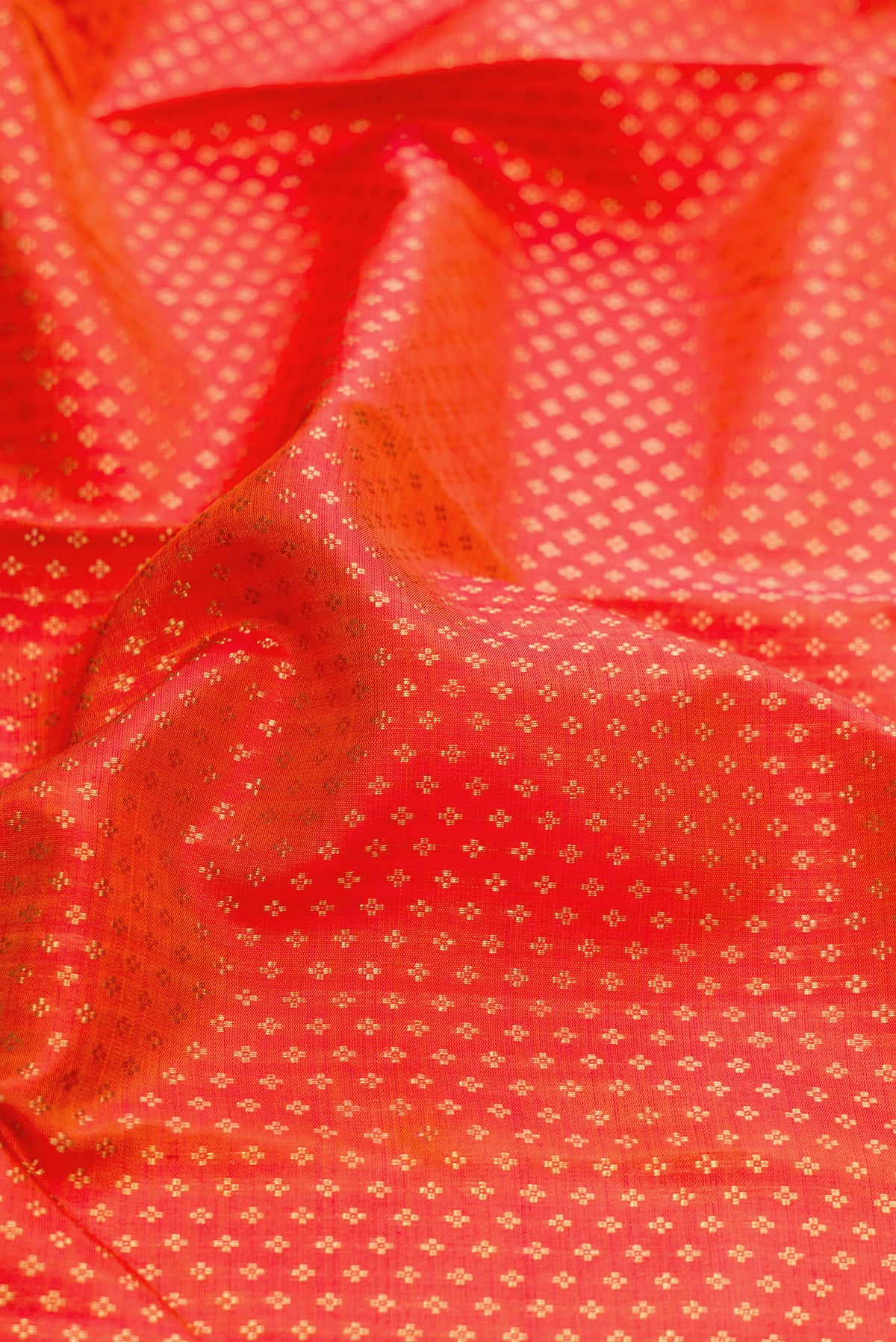 Close up of Pure Silk Pure Zari Orange Dual Tone Kanjivaram Saree with Zari Brocade on the body and Zari Border.  displaying folds