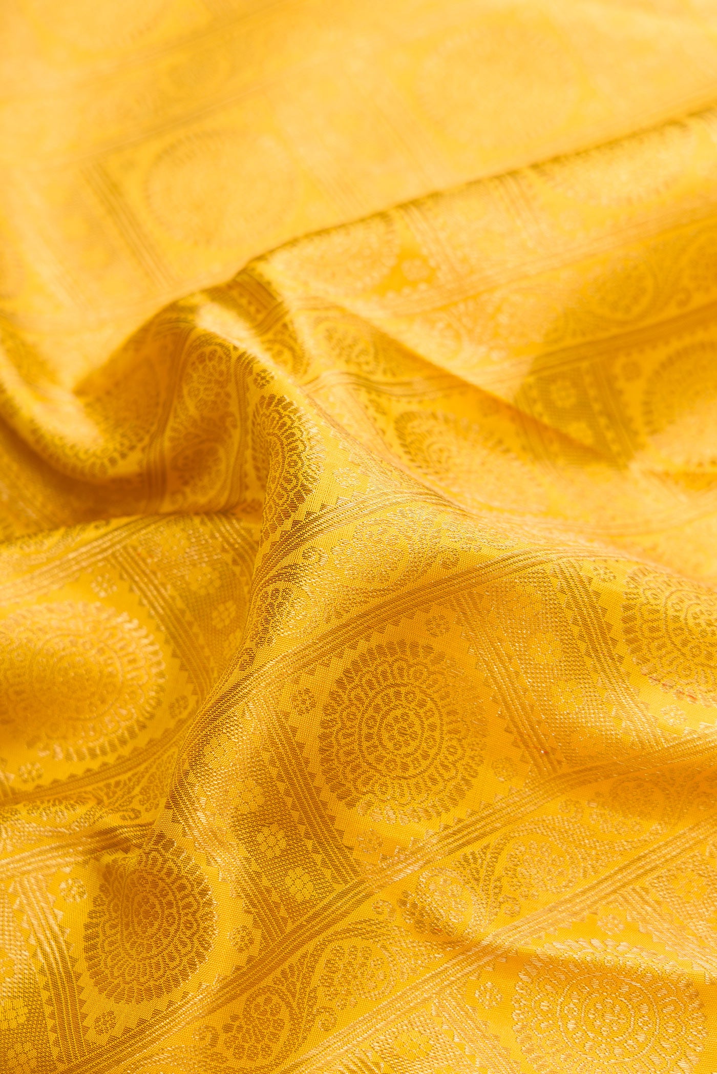 Close up of Yellow Dual Tone Kanjivaram Silk Saree with Zari Brocade on the body and Zari Border.  displaying folds