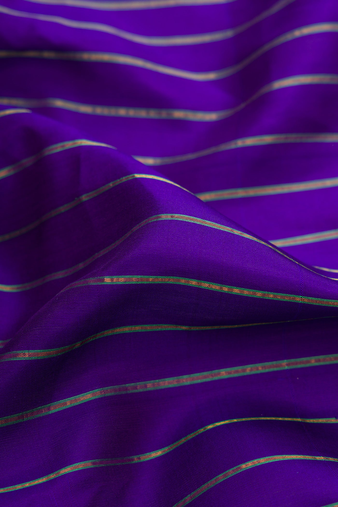Close up of Royal Blue Dual Tone Gadwal Silk Saree with Stripes on the body and Zari Border.  displaying folds
