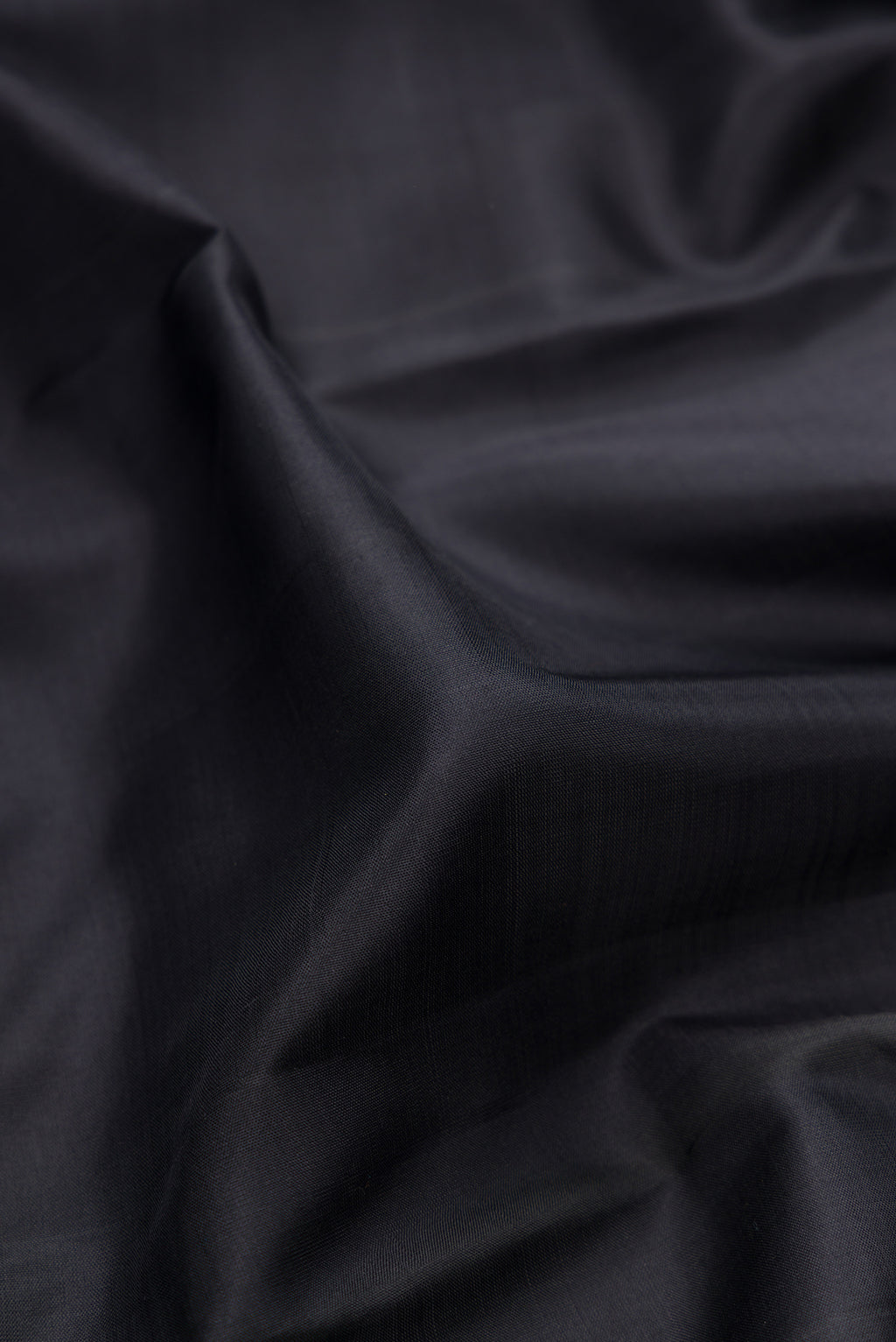 Close up of Black Kanjivaram Silk Saree with Plain Body and Thread Border.  displaying folds