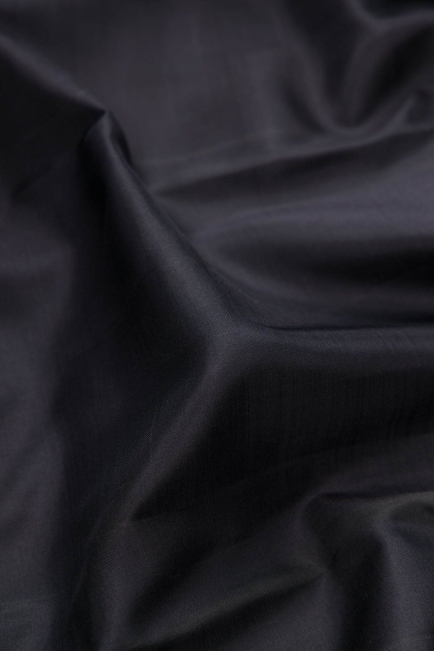Close up of Black Kanjivaram Silk Saree with Plain Body and Thread Border.  displaying folds