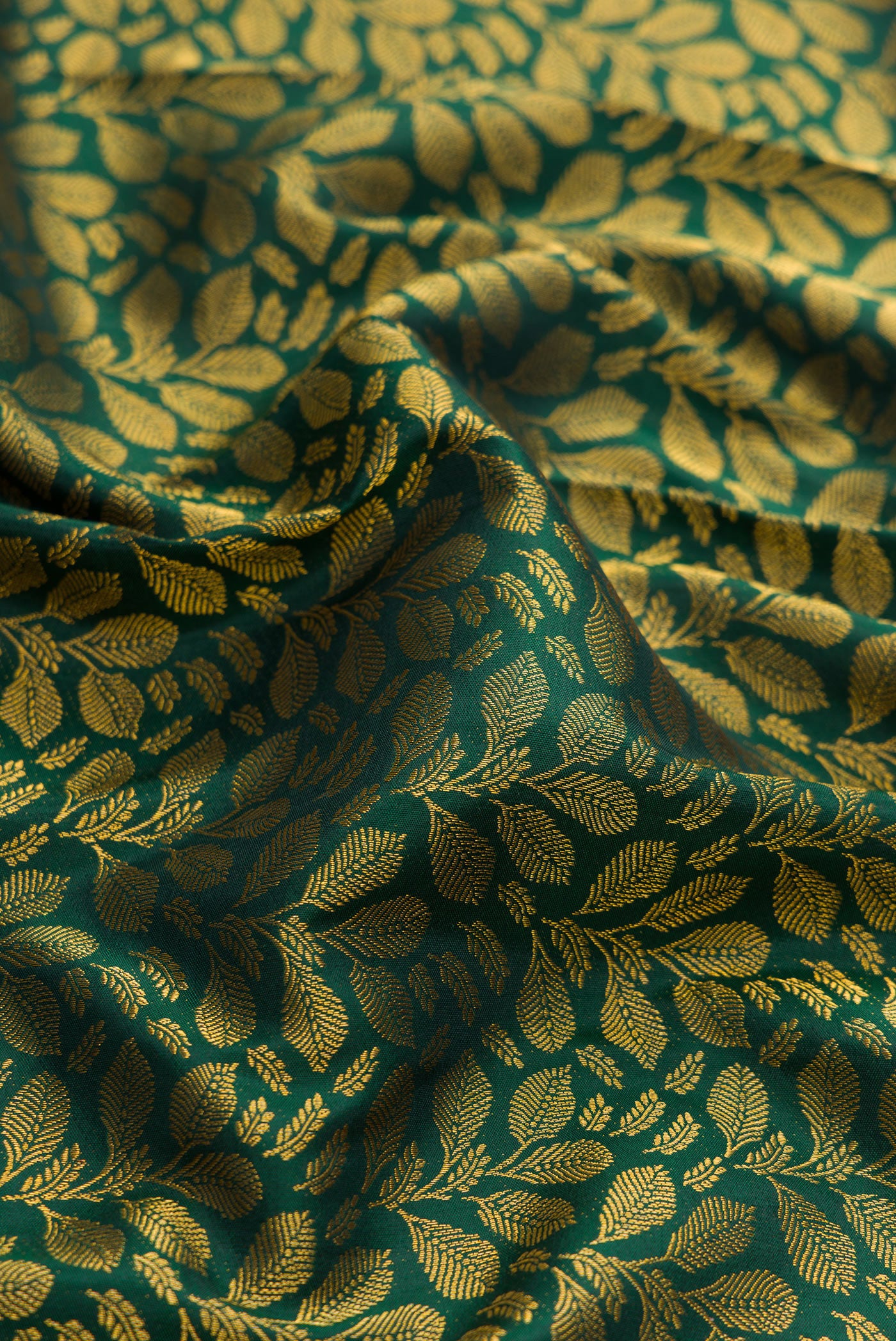 Close up of Green Dual Tone Kanjivaram Silk Saree with Zari Brocade on the body and Zari Border.  displaying folds