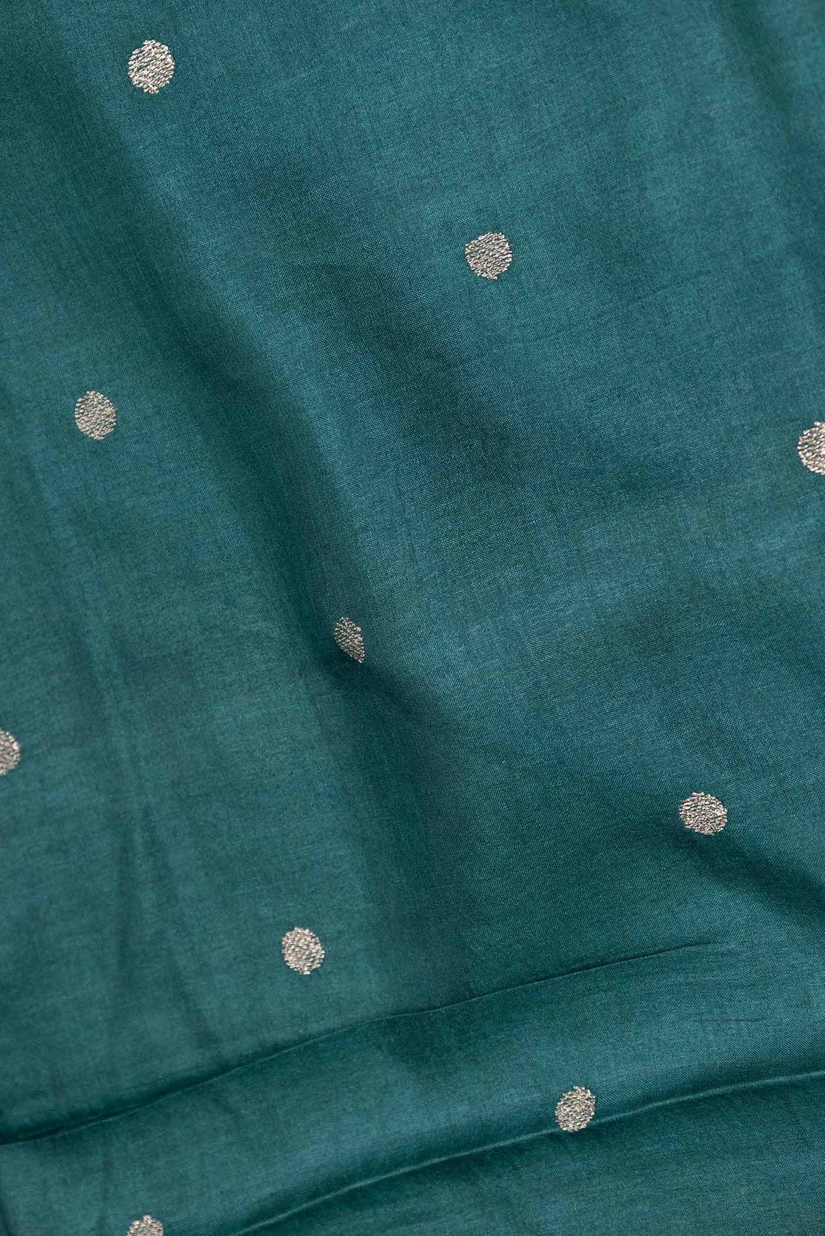 Close up of Peacock Blue Dual Tone Tussar Saree with Zari Butta on the body and Embroidery Border displaying folds