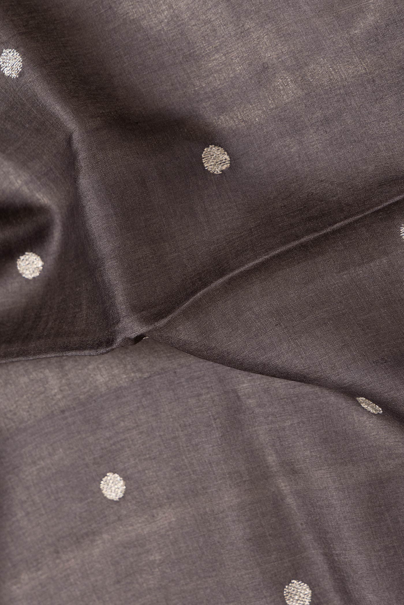 Close up of Brown Dual Tone Tussar Silk Saree with Zari Butta on the body and Embroidery Border.  displaying folds